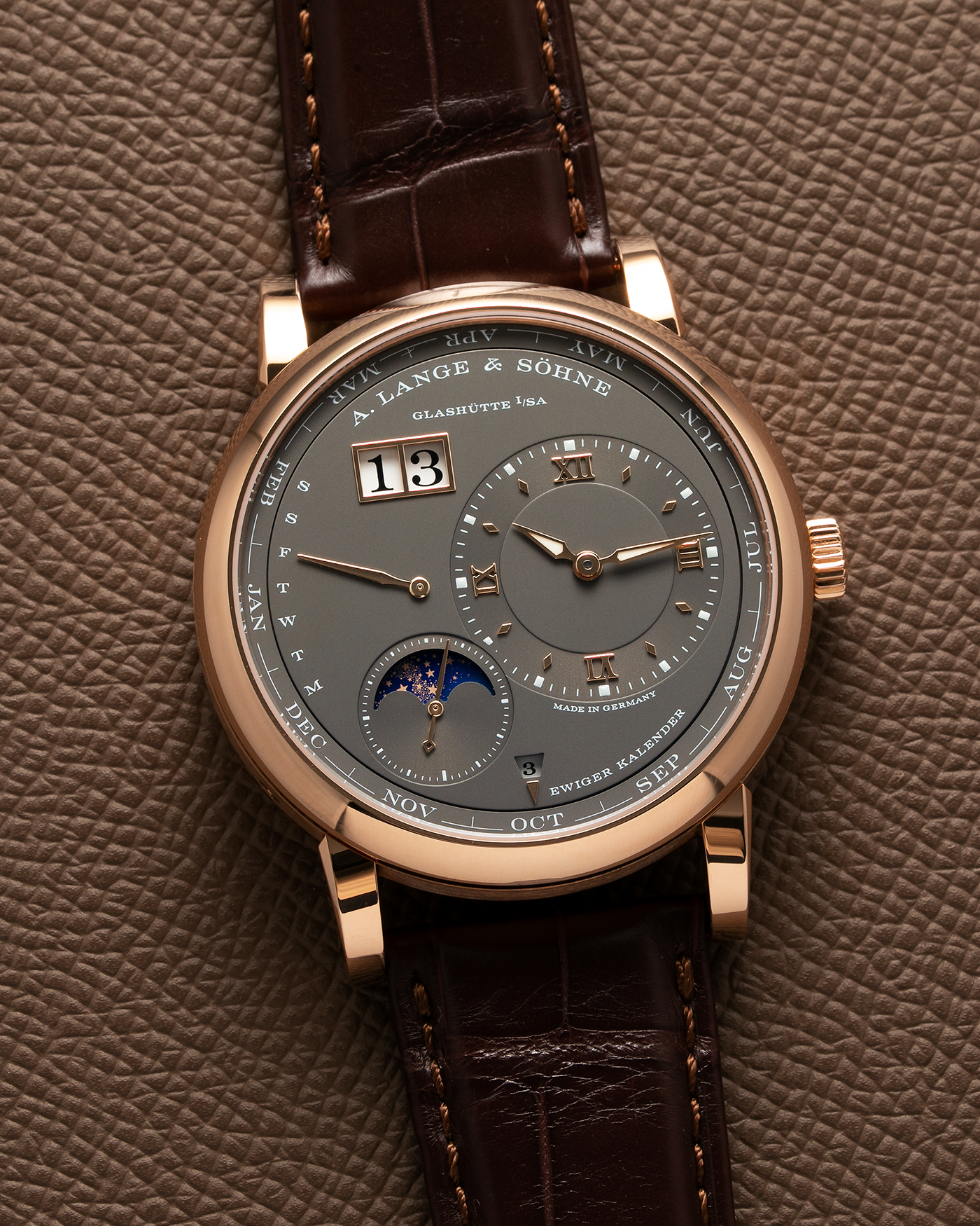 Brand: A. Lange & Söhne Year: 2022 Model: Lange 1 Perpetual Calendar Reference Number: 345.033 E Material: 18-carat Rose Gold Case Movement: A. Lange & Söhne Cal. L021.3, Self-Winding Case Dimensions: 41.9mm x 12.1mm Lug Width: 22mm Strap: A. Lange & Söhne Dark Brown Alligator Strap with 18-carat Rose Gold Tang Buckle, and additional Generic Grey Nubuck Stitched Leather Strap