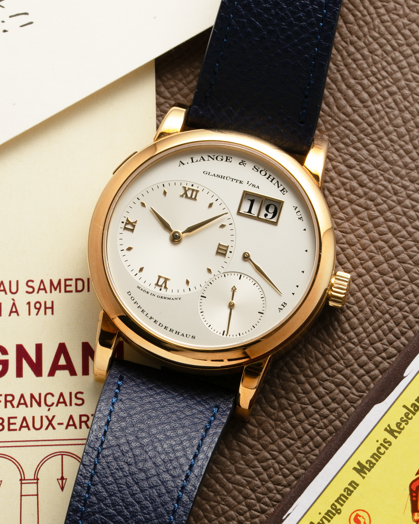 Brand: A. Lange & Söhne Year: 2019 Model: Lange 1 Reference Number: 101.021 Material: 18-carat Yellow Gold Movement: A. Lange & Söhne Cal. L901.0, Manual-Winding Case Diameter: 38.5mm x 9.8mm Lud Width: 20mm Strap: Nostime Blue Calf Leather Strap with Signed 18-carat Yellow Gold Tang Buckle, additional A. Lange & Söhne Brown Alligator Strap