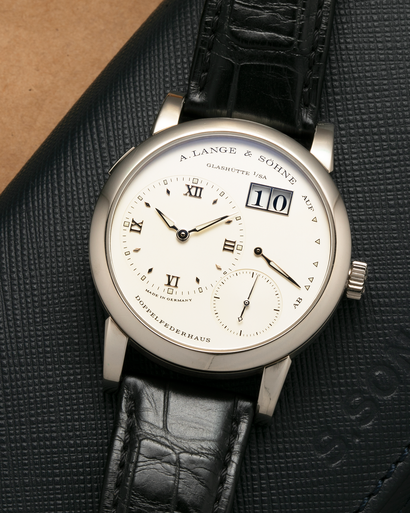 Brand: A. Lange & Söhne
Year: 2010s
Model: Lange 1
Reference: 101.039
Material: 18-carat White Gold
Movement: A. Lange & Söhne Cal. L901.0, Manual-Winding
Case Dimensions: 38.5mm x 9.8mm (Lug-to-Lug 47.3mm)
Lug Width: 20mm
Strap: A. Lange & Söhne Black Alligator Leather Strap with Signed 18-carat White Gold Tang Buckle