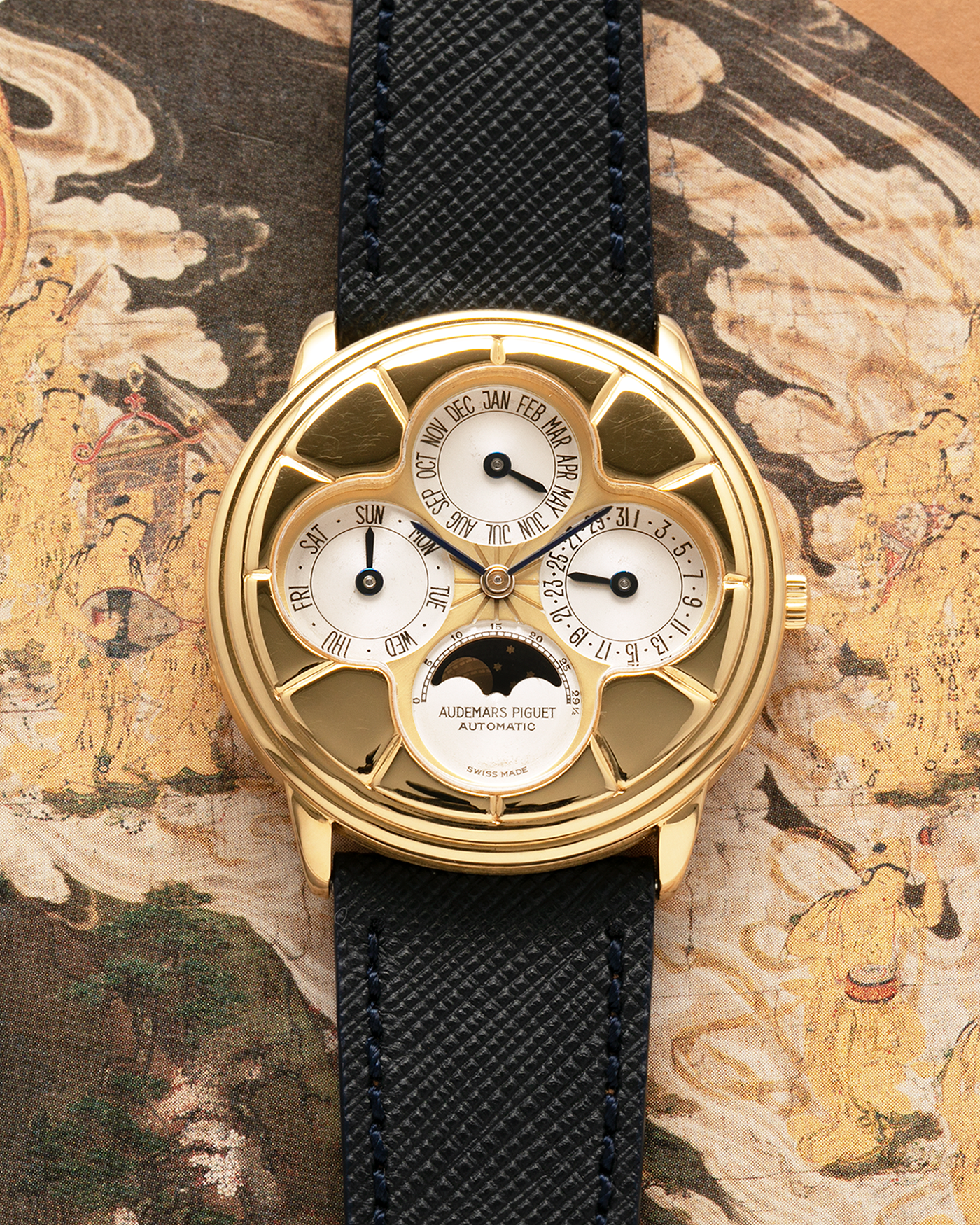 Brand: Audemars Piguet
Year: 1990s
Model: Quantième Perpetual Calendar ‘Clover’
Reference: 25681BA
Material: 18-carat Yellow Gold
Movement: Audemars Piguet Cal. 2120/2, Self-Winding
Case Dimensions: 36mm x 8mm (Lug-to-Lug 38.5mm)
Lug Width: 20mm
Straps: Molequin Dark Navy Textured Calf Leather Strap with 18k Yellow Gold Audemars Piguet Deployant Clasp
