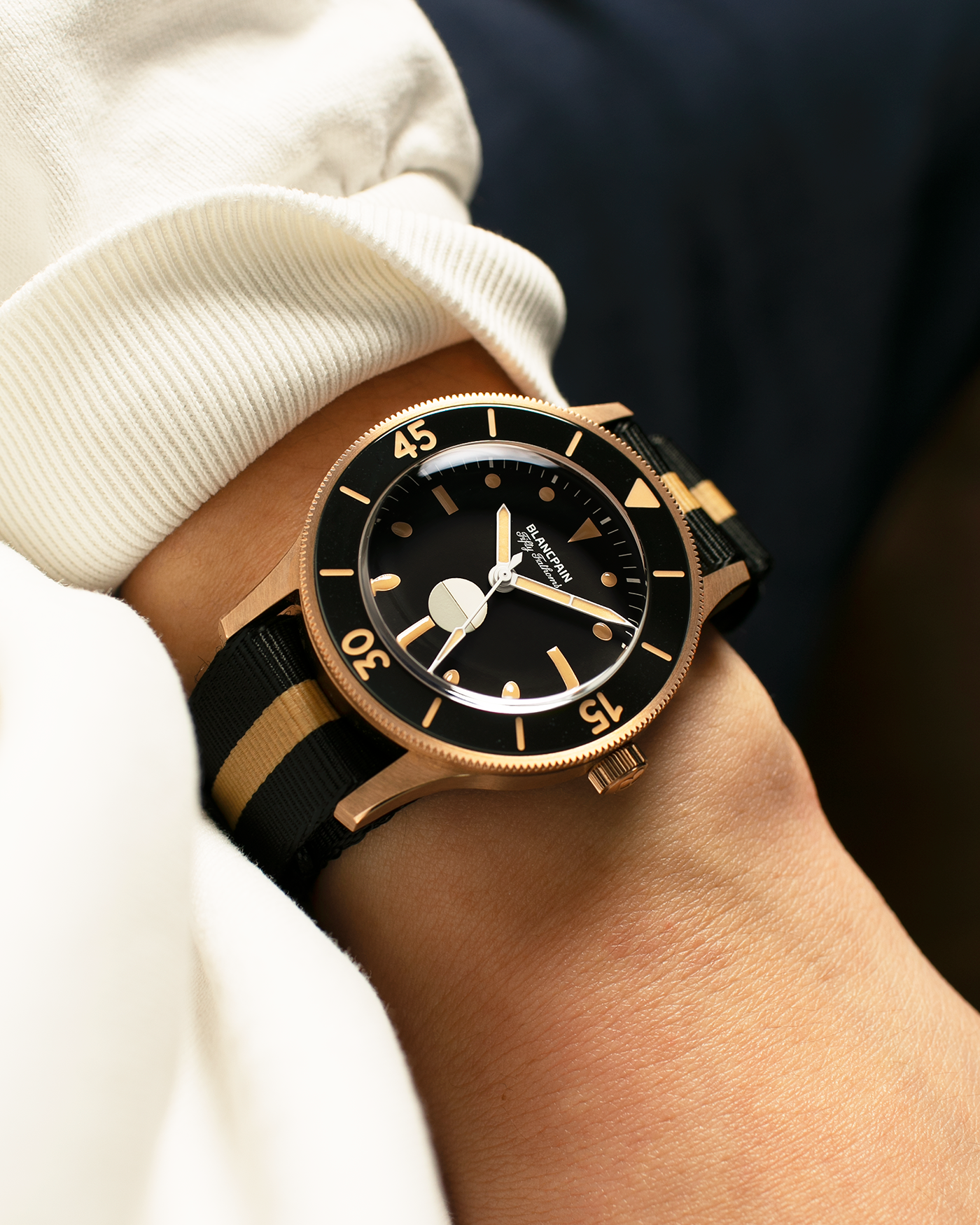 Brand: Blancpain
Year: 2024
Model: Fifty Fathoms 70th Anniversary Act 3, Limited Edition of 555 Pieces
Reference Number: 5901-5630 NANA
Material: 9-carat Bronze Gold, Black Ceramic Bezel Insert
Movement: Blancpain Cal. 1154.P2 (Derived from Blancpain Cal. 1150), Self-Winding
Case Dimensions: 41.3mm x 13.3mm (Lug-to-Lug 41.3mm)
Lug Width: 20mm
Strap: Blancpain Two-Tone NATO Strap with Signed 9-carat Bronze Gold Tang Buckle