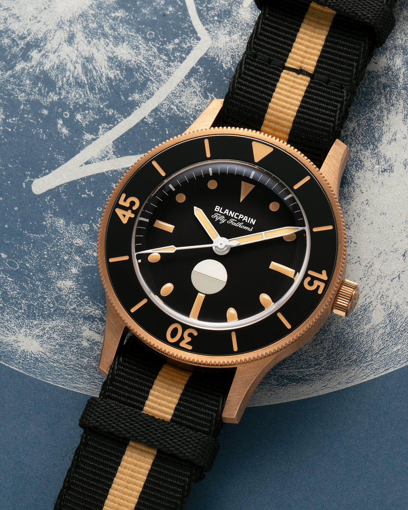 Brand: Blancpain
Year: 2024
Model: Fifty Fathoms 70th Anniversary Act 3, Limited Edition of 555 Pieces
Reference Number: 5901-5630 NANA
Material: 9-carat Bronze Gold, Black Ceramic Bezel Insert
Movement: Blancpain Cal. 1154.P2 (Derived from Blancpain Cal. 1150), Self-Winding
Case Dimensions: 41.3mm x 13.3mm (Lug-to-Lug 41.3mm)
Lug Width: 20mm
Strap: Blancpain Two-Tone NATO Strap with Signed 9-carat Bronze Gold Tang Buckle