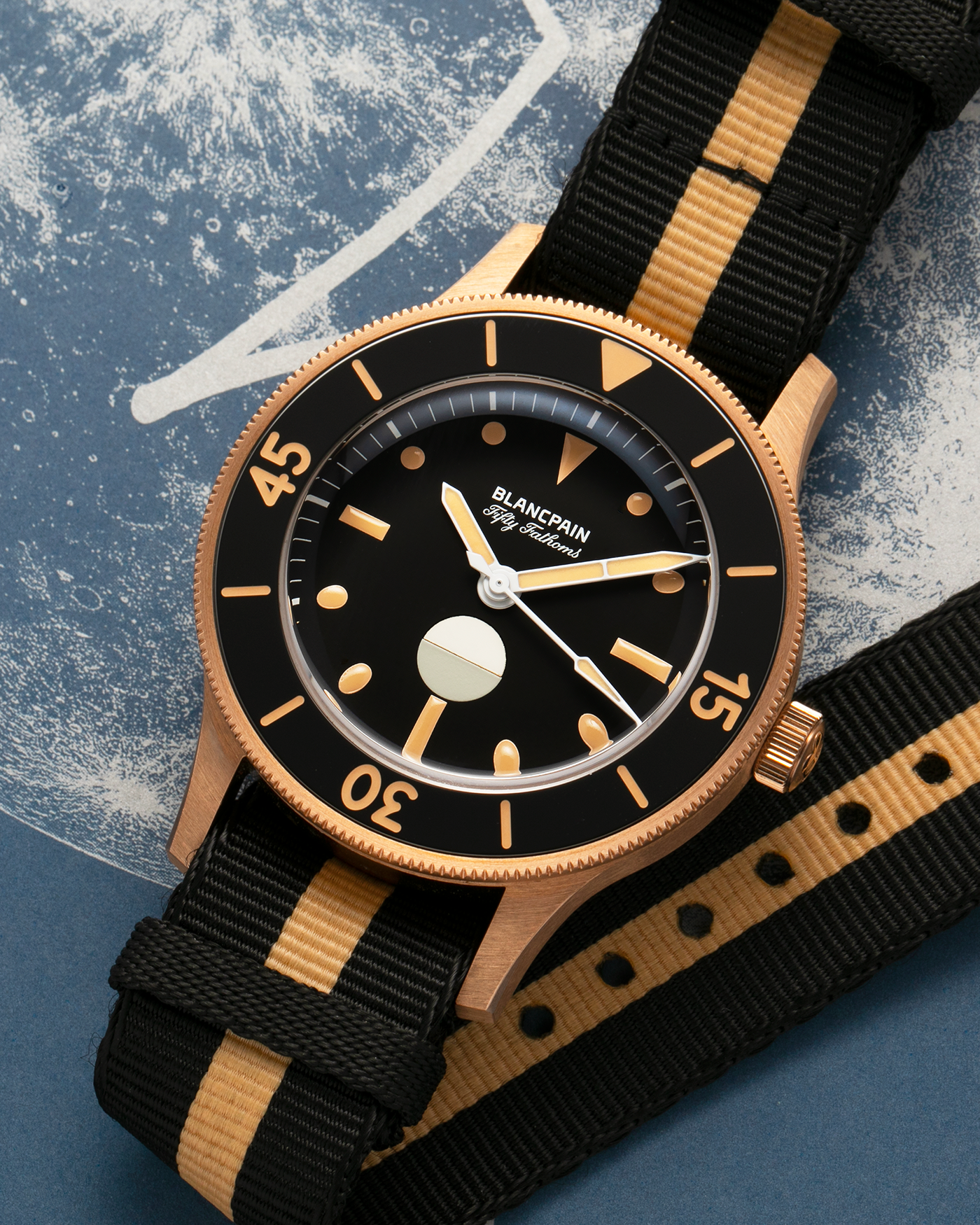 Brand: Blancpain
Year: 2024
Model: Fifty Fathoms 70th Anniversary Act 3, Limited Edition of 555 Pieces
Reference Number: 5901-5630 NANA
Material: 9-carat Bronze Gold, Black Ceramic Bezel Insert
Movement: Blancpain Cal. 1154.P2 (Derived from Blancpain Cal. 1150), Self-Winding
Case Dimensions: 41.3mm x 13.3mm (Lug-to-Lug 41.3mm)
Lug Width: 20mm
Strap: Blancpain Two-Tone NATO Strap with Signed 9-carat Bronze Gold Tang Buckle