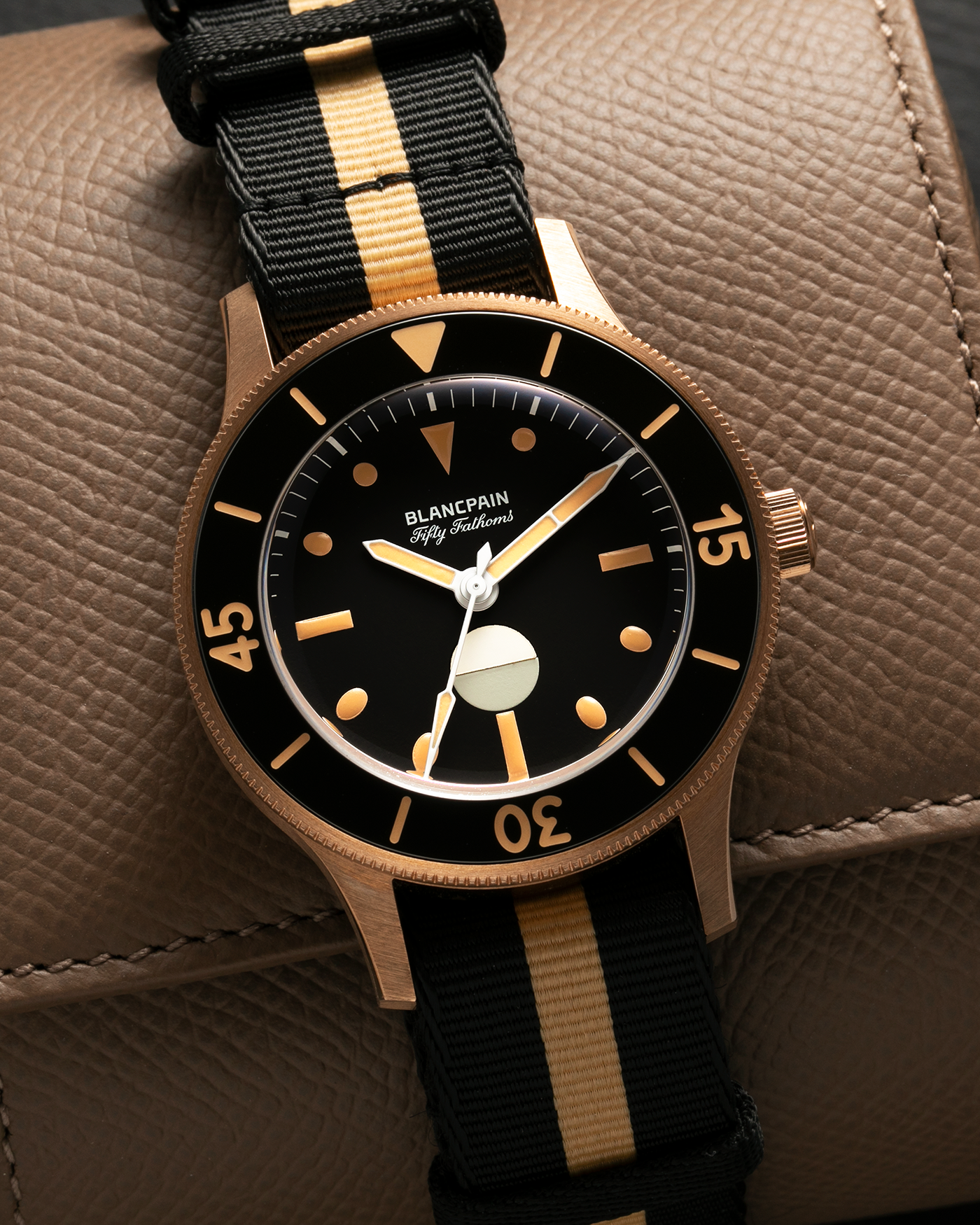 Brand: Blancpain
Year: 2024
Model: Fifty Fathoms 70th Anniversary Act 3, Limited Edition of 555 Pieces
Reference Number: 5901-5630 NANA
Material: 9-carat Bronze Gold, Black Ceramic Bezel Insert
Movement: Blancpain Cal. 1154.P2 (Derived from Blancpain Cal. 1150), Self-Winding
Case Dimensions: 41.3mm x 13.3mm (Lug-to-Lug 41.3mm)
Lug Width: 20mm
Strap: Blancpain Two-Tone NATO Strap with Signed 9-carat Bronze Gold Tang Buckle