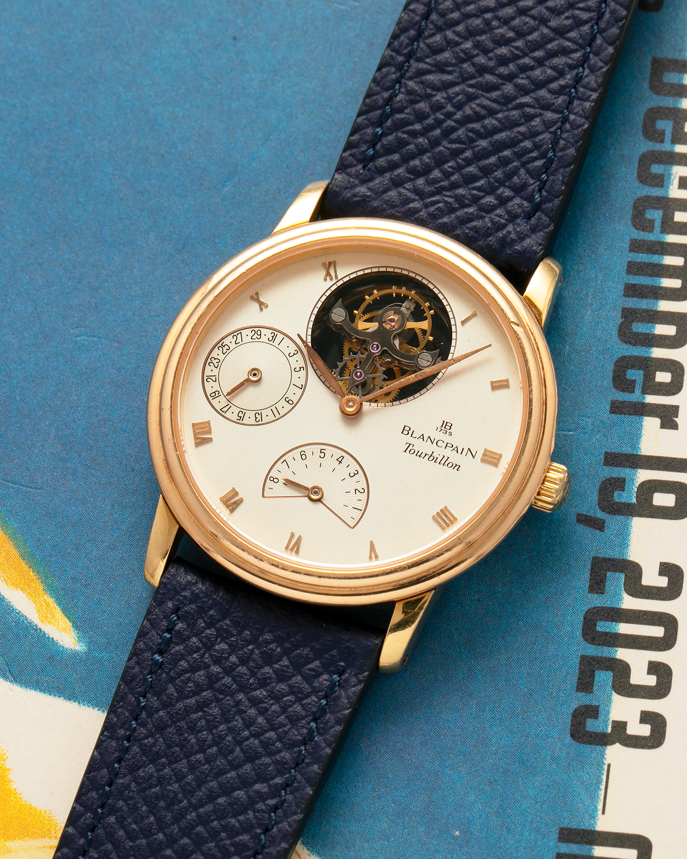 Brand: Blancpain
Year: 1996
Model: Villeret Flying Tourbillon 8 Days, Limited to 99 Pieces Across all Metals
Reference: 0023-1418-55
Material: 18-carat Yellow Gold
Movement: Blancpain Cal. 23, Manual-Winding Flying Tourbillon
Case Dimensions: 34mm x 7.4mm (Lug-to-Lug 40mm)
Lug Width: 19mm
Strap: Nostime Dark Navy Textured Calf Leather Strap with Signed 18-carat Tang Buckle, with extra used Blancpain Black Alligator Leather Strap