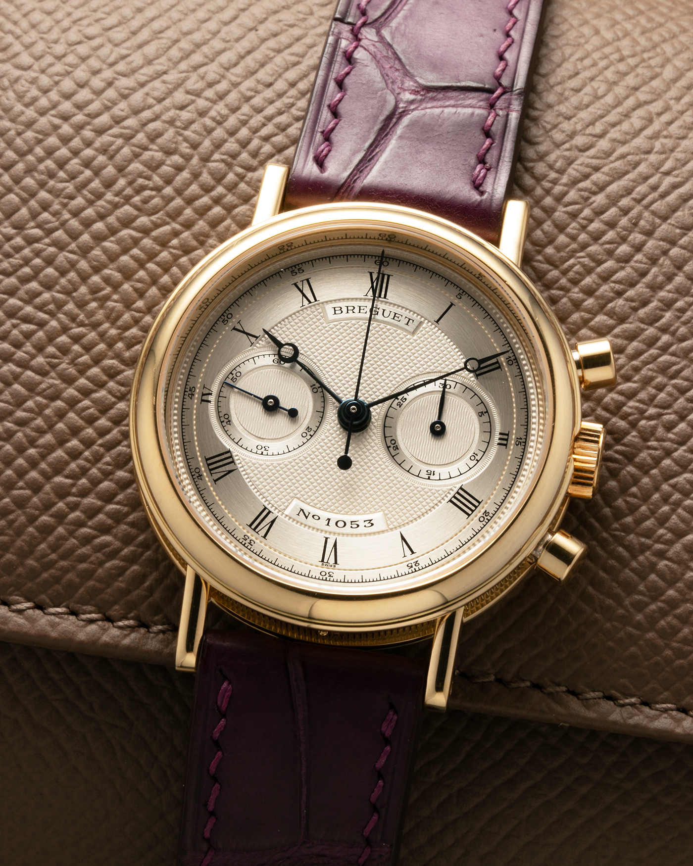 Brand: Breguet
Year: 1990’s
Model: Classique Chronograph
Reference Number: 3237
Material: 18-carat Yellow Gold
Movement: Lemania Cal. 2310, Manual-Winding
Case Dimensions: 36mm x 10mm (Lug-to-Lug 44mm)
Lug Width: 18mm
Strap: Unbranded Dark Purple Alligator Leather Strap with Signed 18-carat Yellow Gold Breguet Tang Buckle