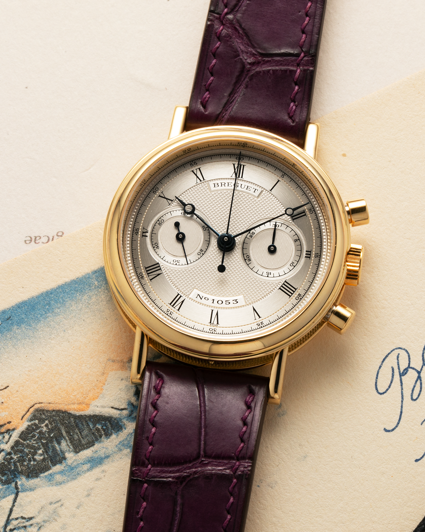 Brand: Breguet
Year: 1990’s
Model: Classique Chronograph
Reference Number: 3237
Material: 18-carat Yellow Gold
Movement: Lemania Cal. 2310, Manual-Winding
Case Dimensions: 36mm x 10mm (Lug-to-Lug 44mm)
Lug Width: 18mm
Strap: Unbranded Dark Purple Alligator Leather Strap with Signed 18-carat Yellow Gold Breguet Tang Buckle