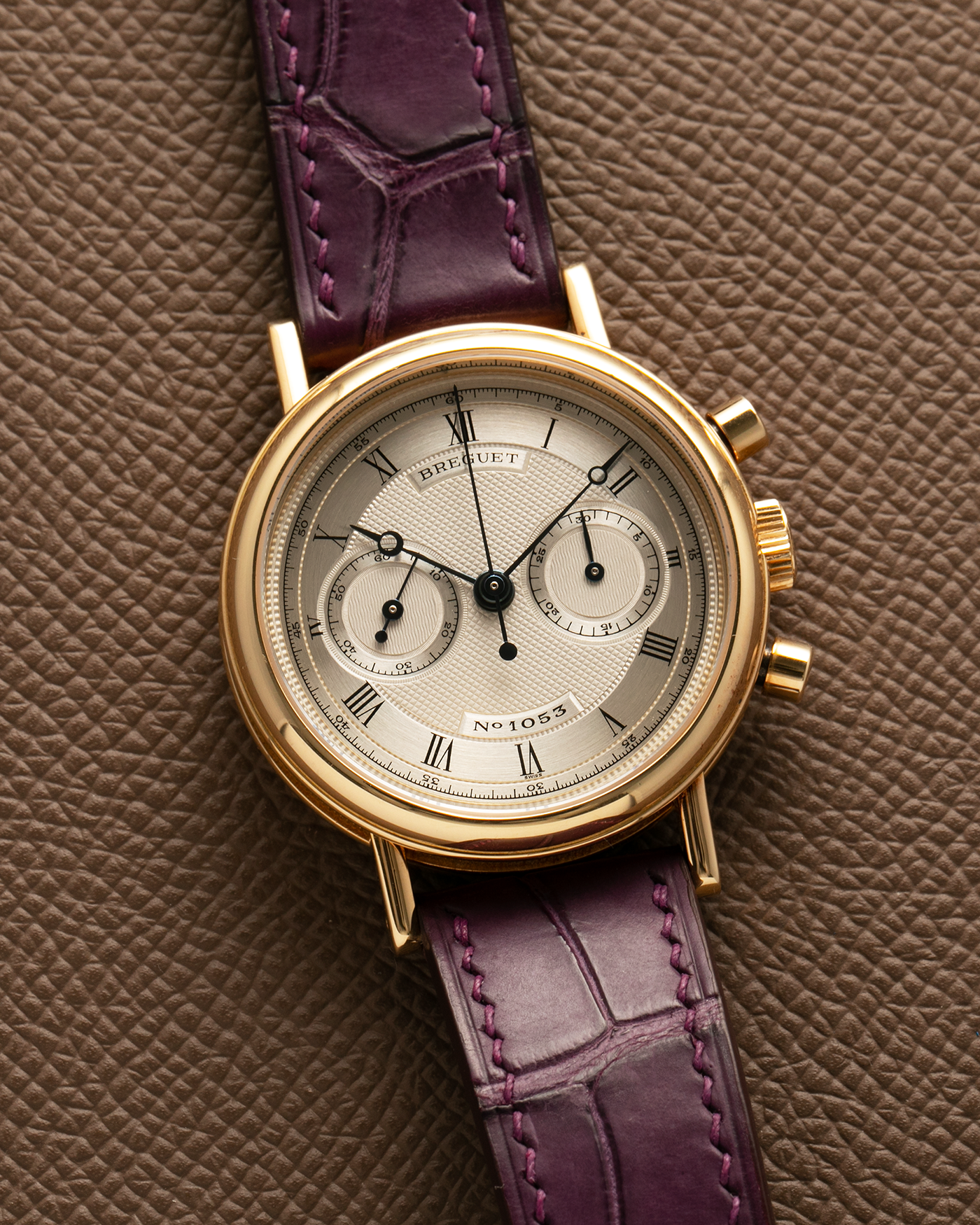 Brand: Breguet Year: 1990’s Model: Classique Chronograph Reference Number: 3237 Material: 18-carat Yellow Gold Movement: Lemania Cal. 2310, Manual-Winding Case Diameter: 36mm Lug Width: 18mm Strap: Unbranded Dark Purple Alligator Leather Strap with Signed 18-carat Yellow Gold Breguet Tang Buckle
