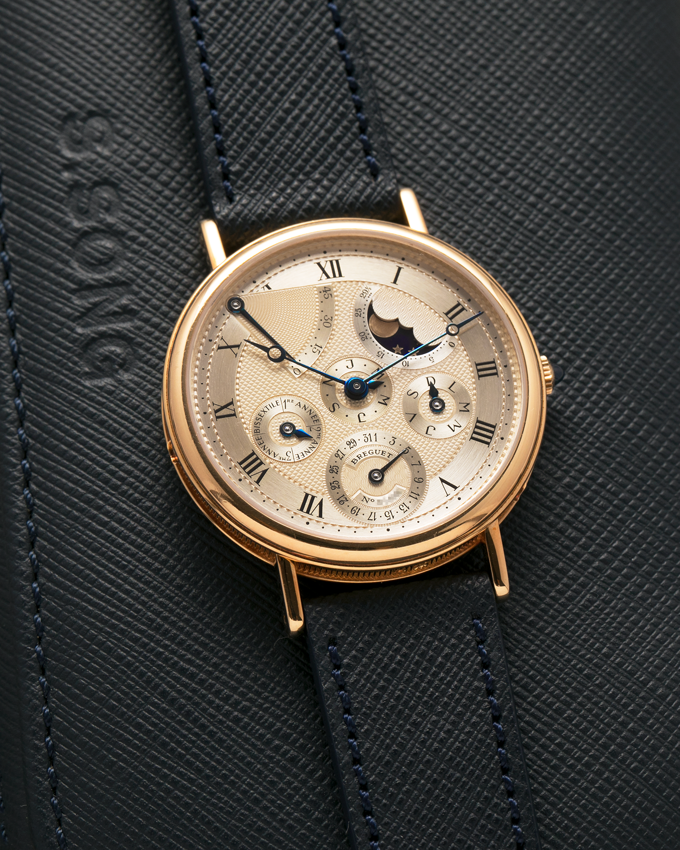 Brand: Breguet
Year: 1994 C Series
Model: Classique Quantième Perpétuel
Reference: 3310BA
Material: 18-carat Yellow Gold
Movement: Breguet Cal. 502 DRP, Self-Winding (based on the Frédéric Piguet Cal. 71)
Case Dimensions: 36mm x 8mm (Lug-to-Lug mm 43.5mm)
Lug Width: 18 mm
Strap: Molequin Dark Navy Textured Calf Leather Strap with Signed 18-carat Yellow Gold Tang Buckle