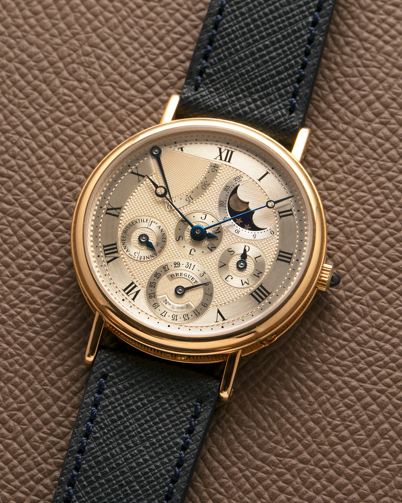 Brand: Breguet
Year: 1994 C Series
Model: Classique Quantième Perpétuel
Reference: 3310BA
Material: 18-carat Yellow Gold
Movement: Breguet Cal. 502 DRP, Self-Winding (based on the Frédéric Piguet Cal. 71)
Case Dimensions: 36mm x 8mm (Lug-to-Lug mm 43.5mm)
Lug Width: 18 mm
Strap: Molequin Dark Navy Textured Calf Leather Strap with Signed 18-carat Yellow Gold Tang Buckle
