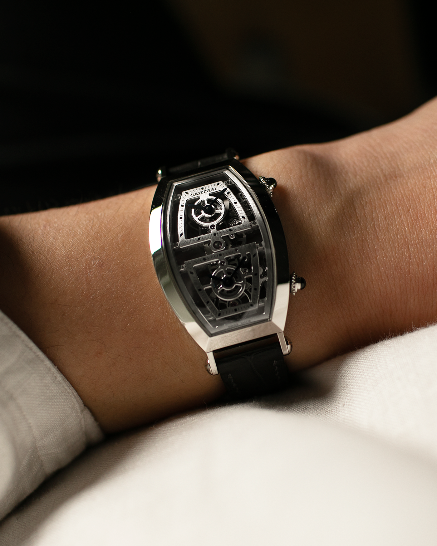 Brand: Cartier Year: 2022 Model: Privé Tonneau Skeleton Dual Time, Limited Edition of 100 pieces only Reference: CRWHTN0006 Material: Platinum 950 Case, 18-carat White Gold Deployant Clasp Movement: Cartier Cal. 9919 MC, Manual-Winding Case Dimensions: 52.4mm x 29.4mm Strap: Cartier Navy Alligator Leather Strap with Signed 18-carat White Gold Deployant Clasp, with two additional Cartier Black and Blue Alligator Leather Straps