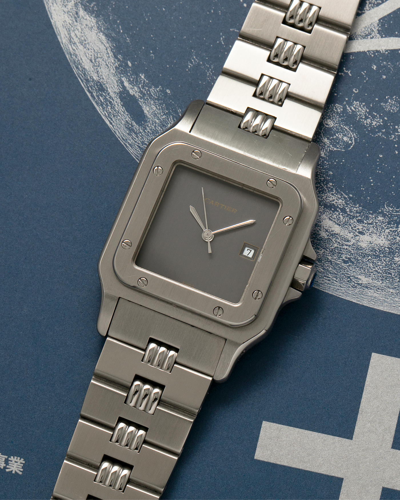 Brand: Cartier Year: 1980s Model: Santos ‘Carrée’ Reference: 2960 Material: Stainless Steel Movement: Cartier Cal. 077 (ETA Cal. 3671 Based), Self-Winding Case Dimensions: 29mm x 40.5mm Lug Width: 18mm Strap: Cartier Stainless Steel Godron ‘541811’ Bracelet with Signed Clasp