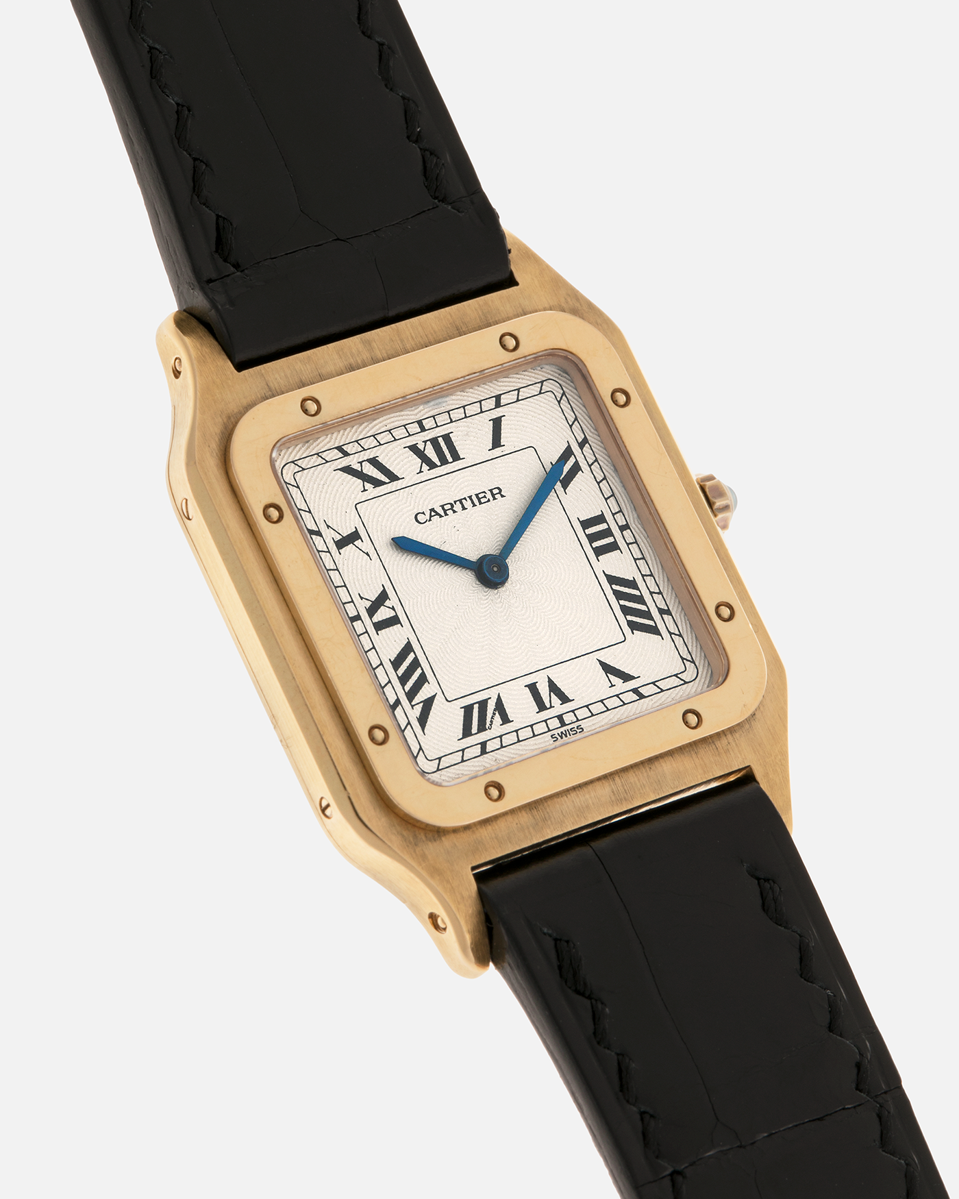Brand: Cartier
Year: 1990s
Model: Santos Dumont
Reference: 1576
Material: 18-carat Yellow Gold
Movement: Cartier Cal. 021MC (Based on Frédéric Piguet 21 ébauche), Manual-Winding
Case Dimensions: 27mm x 6.5mm (Lug-to-Lug 36mm)
Lug Width: 17mm
Strap: Generic Unnamed Black Calf Leather Strap with Cartier Style Gold Plated Tang Buckle, Cartier Black Alligator Leather Strap