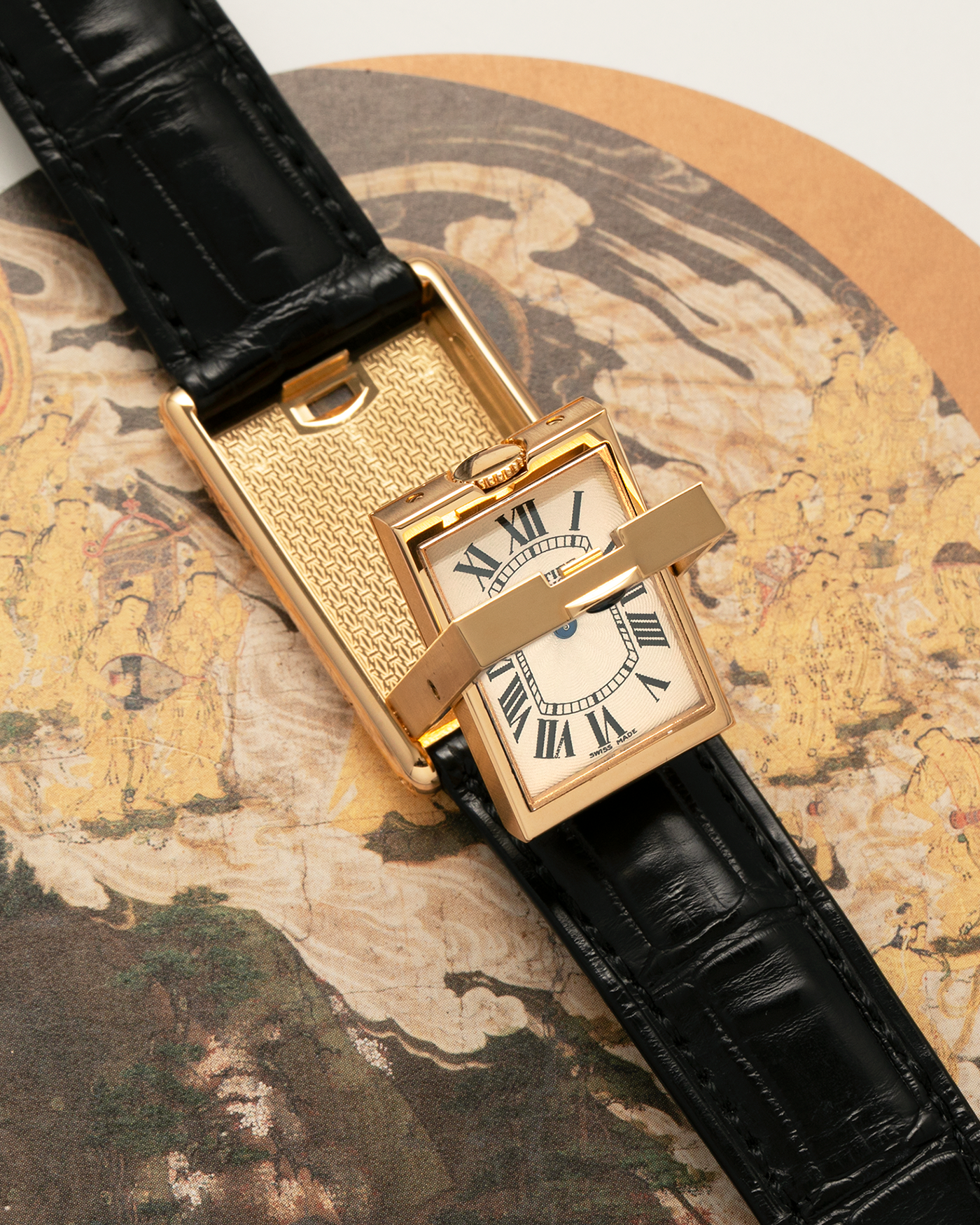 Brand: Cartier
Year: 2000
Model: Tank Basculante Collection Privé CPCP Millenium, Limited to 365 Pieces
Reference: 2391
Material: 18-carat Yellow Gold
Movement: Cartier Cal. 610 (Frédéric Piguet), Manual-Winding
Case Dimensions: 25mm x 39mm (Lug-to-Lug 38.7mm)
Lug Width: 20mm
Strap: Unnamed Padded Black Alligator Leather Strap with Signed 18-carat Yellow Gold Deployant Clasp