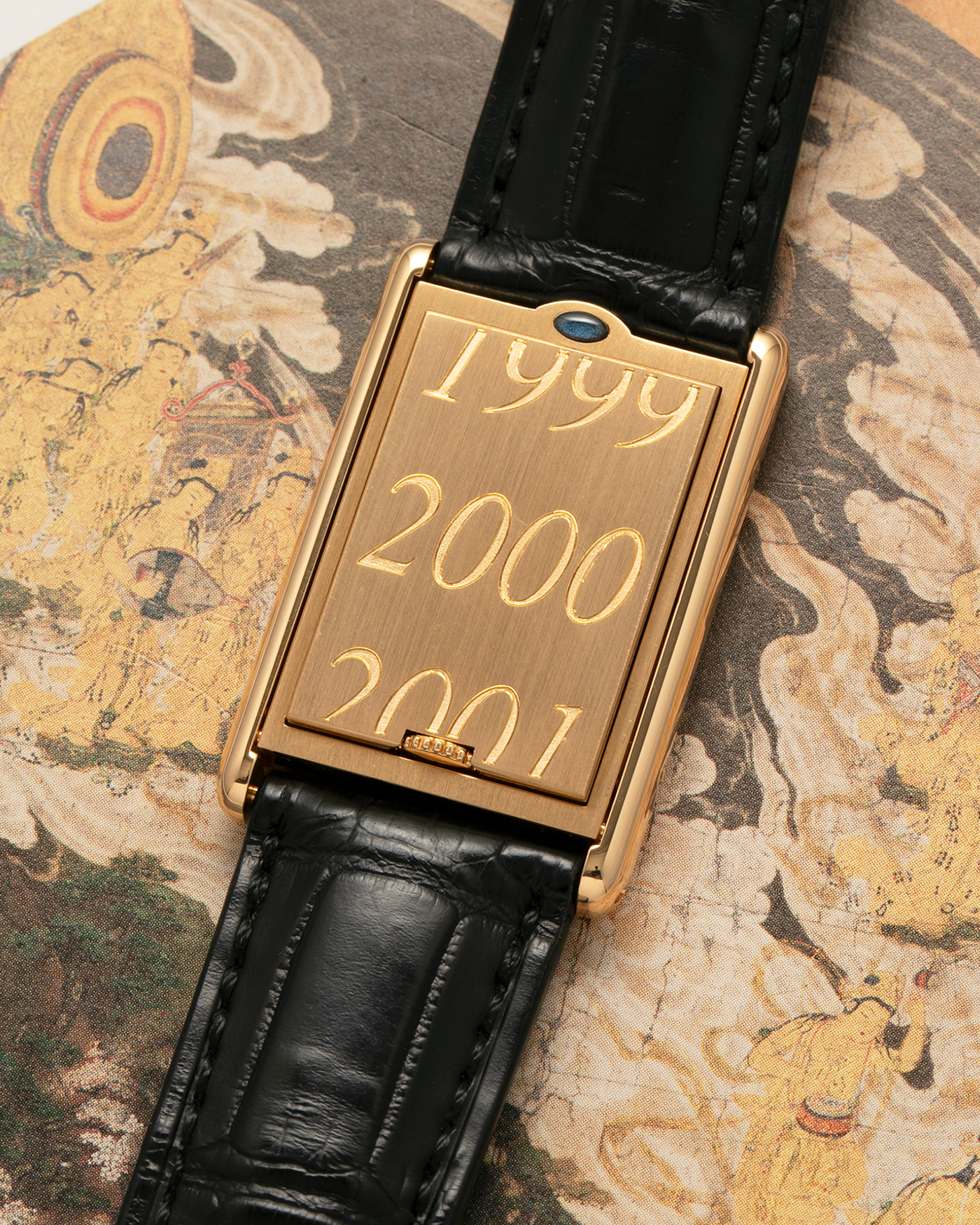 Brand: Cartier
Year: 2000
Model: Tank Basculante Collection Privé CPCP Millenium, Limited to 365 Pieces
Reference: 2391
Material: 18-carat Yellow Gold
Movement: Cartier Cal. 610 (Frédéric Piguet), Manual-Winding
Case Dimensions: 25mm x 39mm (Lug-to-Lug 38.7mm)
Lug Width: 20mm
Strap: Unnamed Padded Black Alligator Leather Strap with Signed 18-carat Yellow Gold Deployant Clasp
