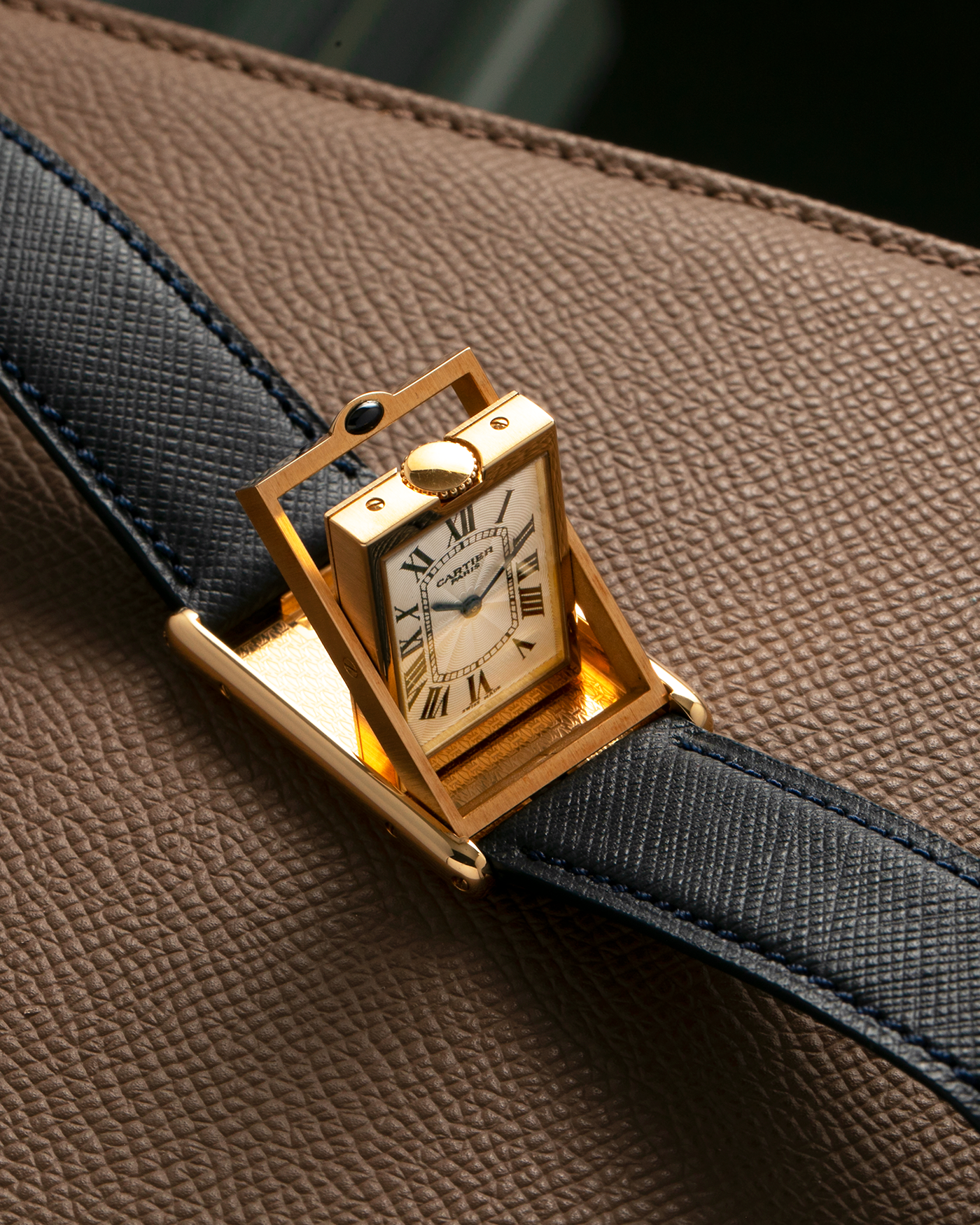 Brand: Cartier Year: 2000s Model: Collection Privée Cartier Paris Tank Basculante Material: 18-carat Yellow Gold Movement: Cartier Cal. 060MC (F. Piguet Cal. 610), Manual-Winding Case Diameter: 25mm x 39mm Lug Width: 20mm Strap: Nostime Navy Textured Calf Leather Strap with Signed 18-carat Yellow Gold Deployant Clasp, additional Cartier Brown Textured Calf Leather Strap (Used)