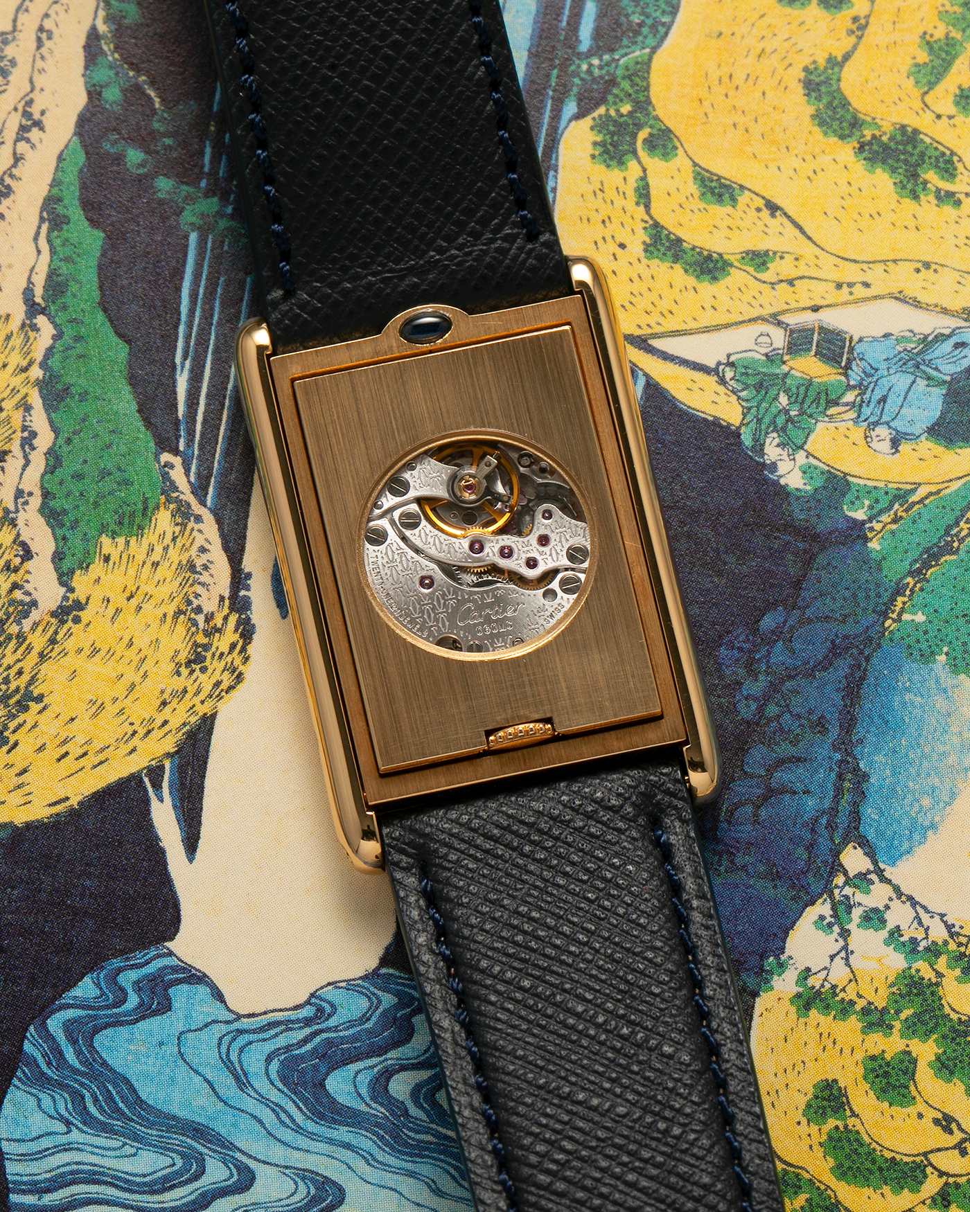Brand: Cartier Year: 2000s Model: Collection Privée Cartier Paris Tank Basculante Material: 18-carat Yellow Gold Movement: Cartier Cal. 060MC (F. Piguet Cal. 610), Manual-Winding Case Diameter: 25mm x 39mm Lug Width: 20mm Strap: Nostime Navy Textured Calf Leather Strap with Signed 18-carat Yellow Gold Deployant Clasp, additional Cartier Brown Textured Calf Leather Strap (Used)