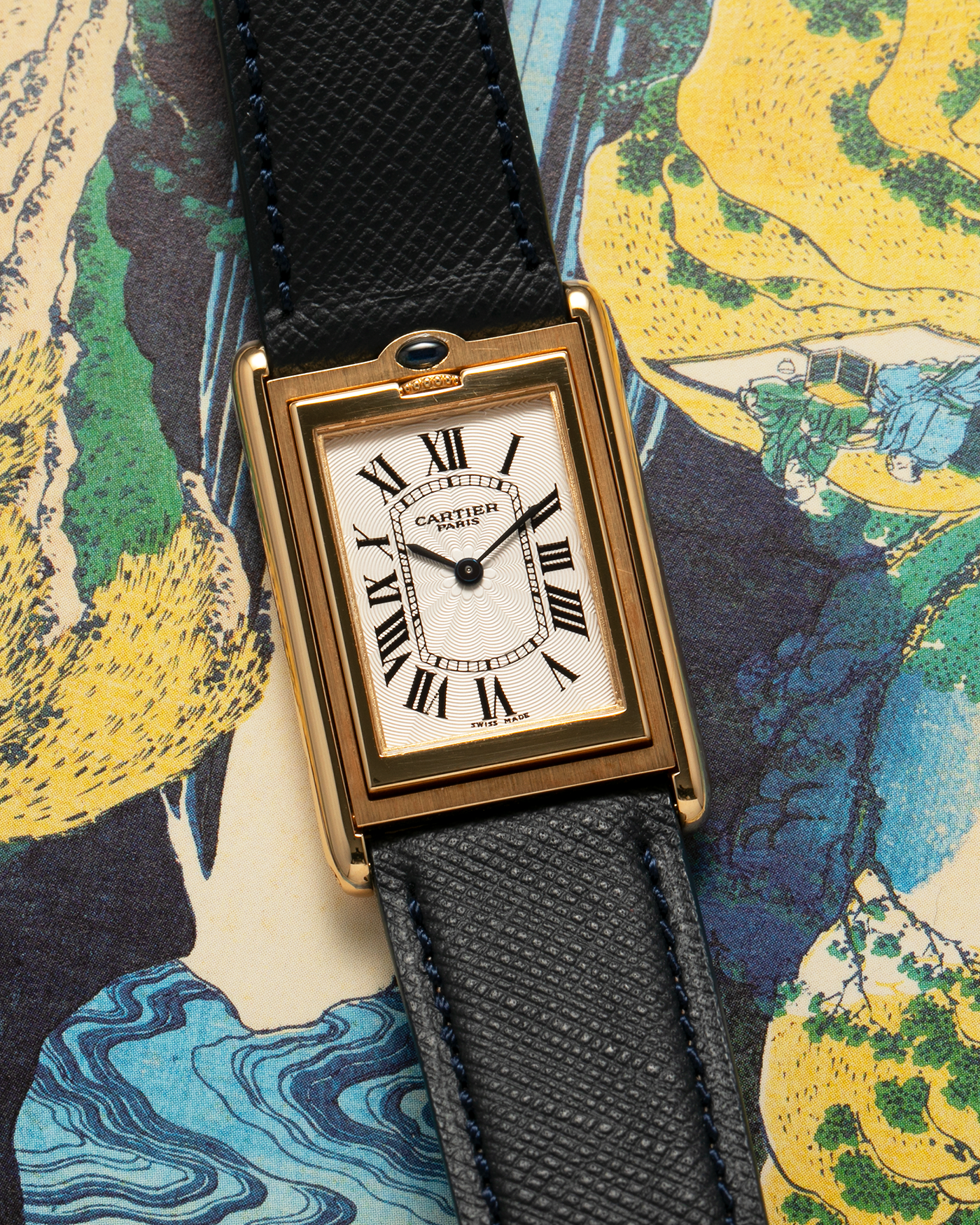 Brand: Cartier Year: 2000s Model: Collection Privée Cartier Paris Tank Basculante Material: 18-carat Yellow Gold Movement: Cartier Cal. 060MC (F. Piguet Cal. 610), Manual-Winding Case Diameter: 25mm x 39mm Lug Width: 20mm Strap: Nostime Navy Textured Calf Leather Strap with Signed 18-carat Yellow Gold Deployant Clasp, additional Cartier Brown Textured Calf Leather Strap (Used)