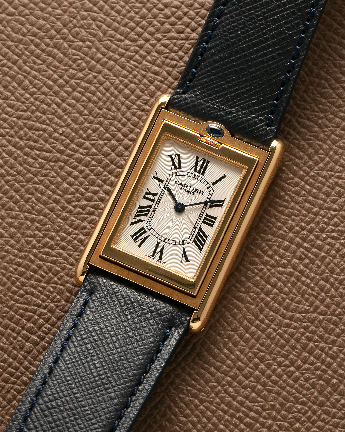 Brand: Cartier Year: 2000s Model: Collection Privée Cartier Paris Tank Basculante Material: 18-carat Yellow Gold Movement: Cartier Cal. 060MC (F. Piguet Cal. 610), Manual-Winding Case Diameter: 25mm x 39mm Lug Width: 20mm Strap: Nostime Navy Textured Calf Leather Strap with Signed 18-carat Yellow Gold Deployant Clasp, additional Cartier Brown Textured Calf Leather Strap (Used)