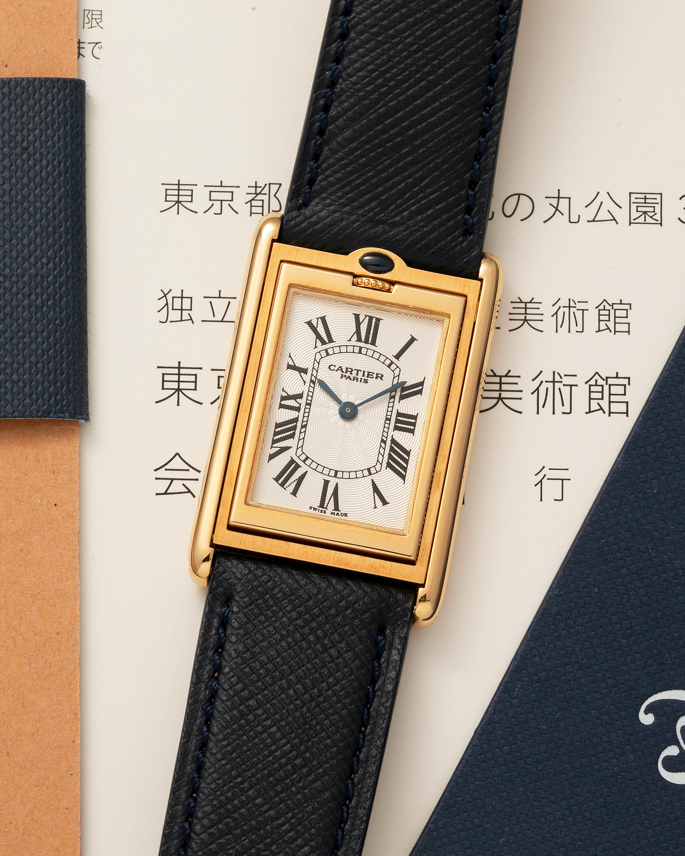Brand: Cartier Year: 2000s Model: Collection Privée Cartier Paris Tank Basculante Material: 18-carat Yellow Gold Movement: Cartier Cal. 060MC (F. Piguet Cal. 610), Manual-Winding Case Diameter: 25mm x 39mm Lug Width: 20mm Strap: Nostime Navy Textured Calf Leather Strap with Signed 18-carat Yellow Gold Deployant Clasp, additional Cartier Brown Textured Calf Leather Strap (Used)