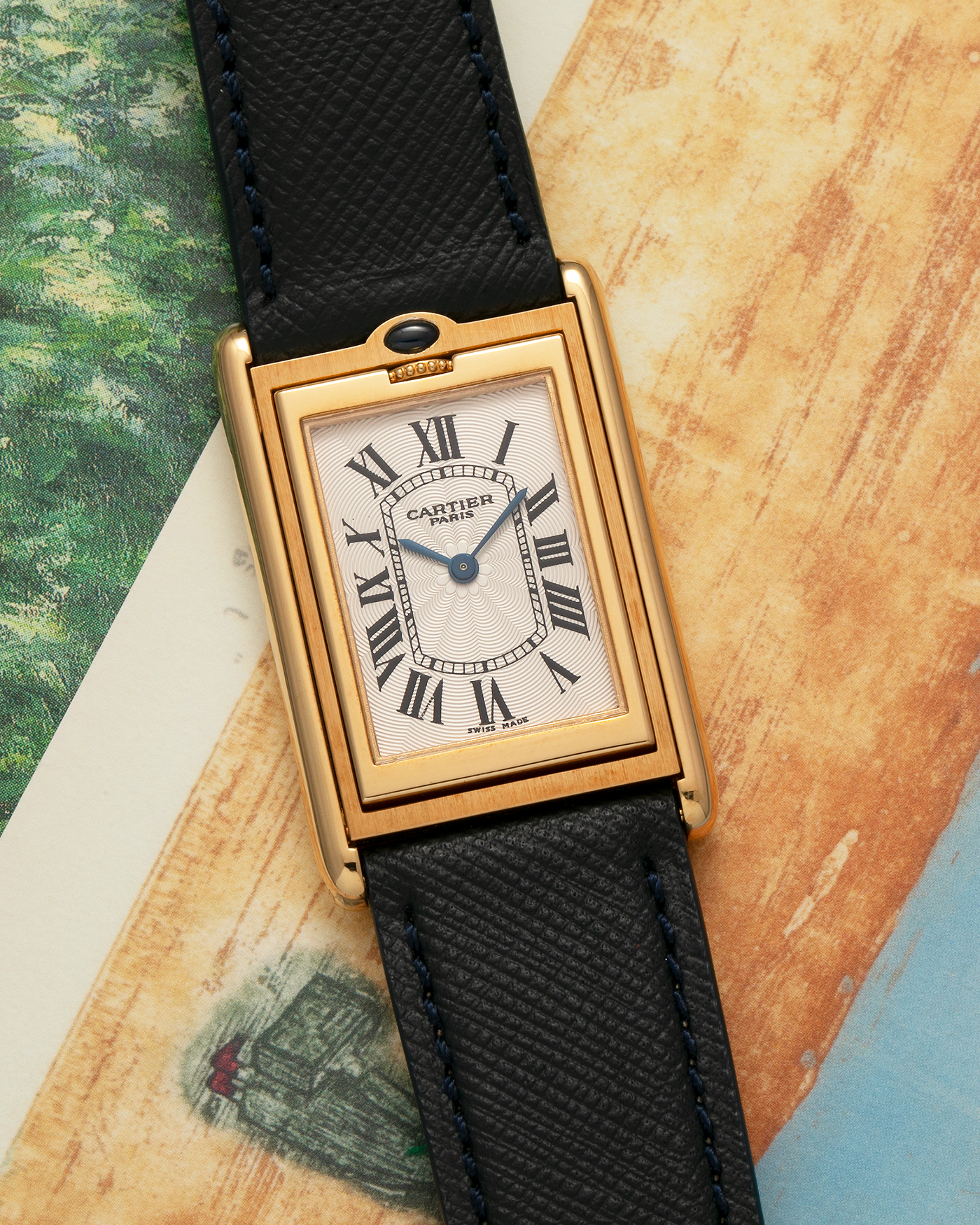 Brand: Cartier Year: 2000s Model: Collection Privée Cartier Paris Tank Basculante Material: 18-carat Yellow Gold Movement: Cartier Cal. 060MC (F. Piguet Cal. 610), Manual-Winding Case Diameter: 25mm x 39mm Lug Width: 20mm Strap: Nostime Navy Textured Calf Leather Strap with Signed 18-carat Yellow Gold Deployant Clasp, additional Cartier Brown Textured Calf Leather Strap (Used)