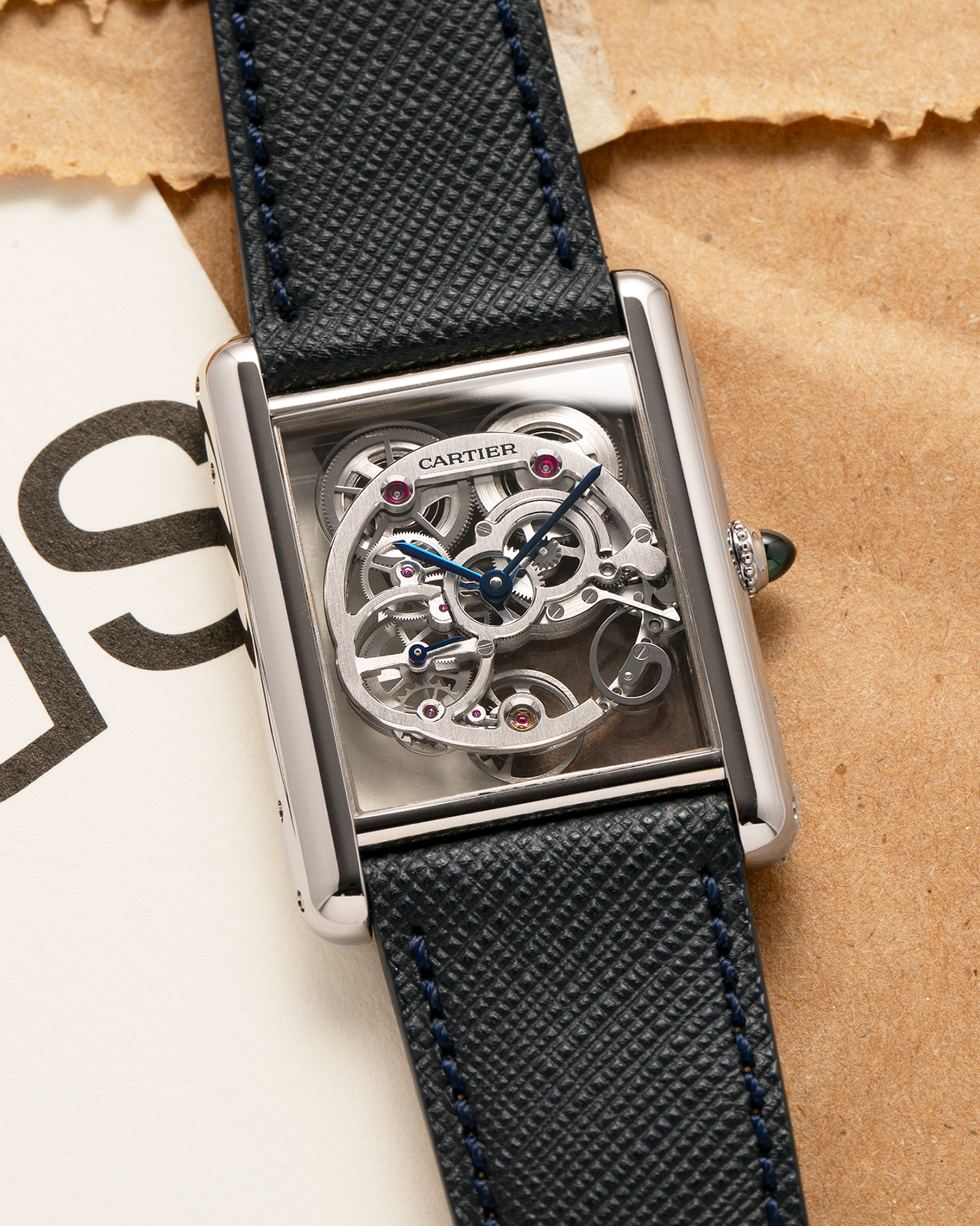 Brand: Cartier
Year: 2015
Model: Tank Louis Cartier Sapphire Skeleton
Reference: W5310012
Material: 18k White Gold
Movement: Manual-Winding Cartier Calibre 9616 MC
Case Dimensions: 39.2mm by 30mm, 7.45mm Thickness
Strap: Navy Blue Molequin Textured Calf Strap, Grey Blue Cartier Alligator Strap, Sealed Black Cartier Alligator Strap with 18k White Gold Cartier Deployant Buckle