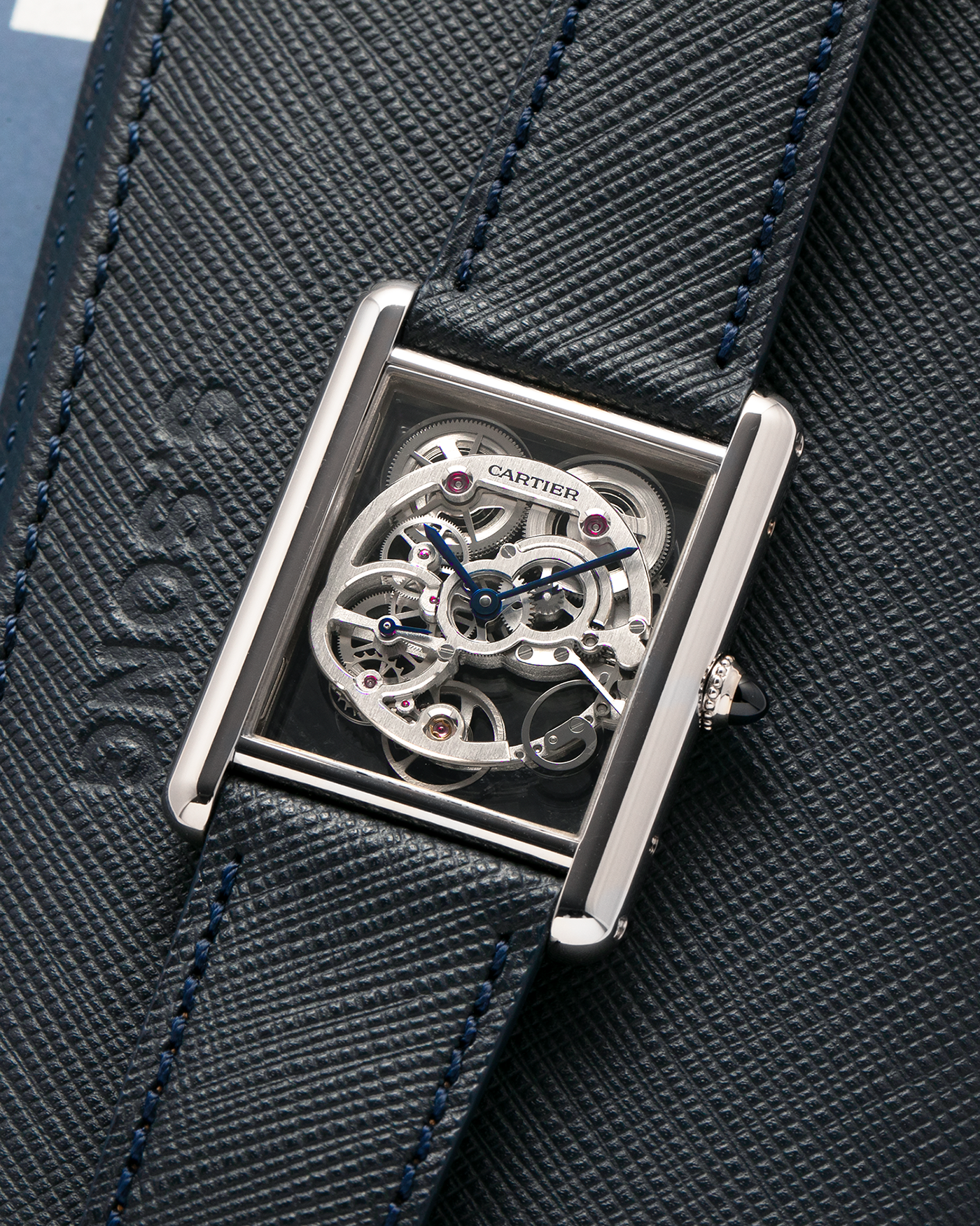 Brand: Cartier
Year: 2015
Model: Tank Louis Cartier Sapphire Skeleton
Reference: W5310012
Material: 18k White Gold
Movement: Manual-Winding Cartier Calibre 9616 MC
Case Dimensions: 39.2mm by 30mm, 7.45mm Thickness
Strap: Navy Blue Molequin Textured Calf Strap, Grey Blue Cartier Alligator Strap, Sealed Black Cartier Alligator Strap with 18k White Gold Cartier Deployant Buckle