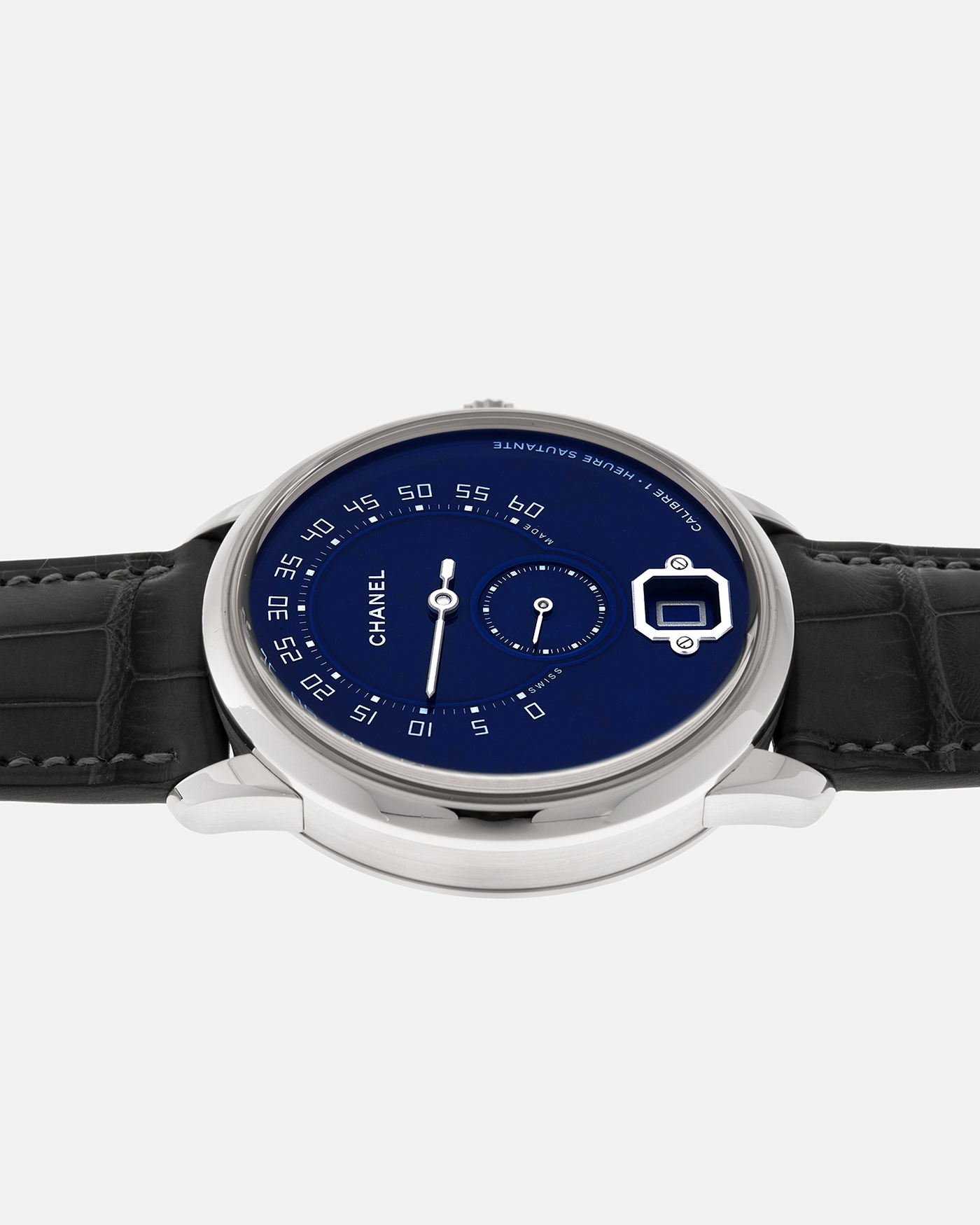 Brand: Chanel
Year: 2018
Model: Monsieur De Chanel Jump Hour, Limited to 20 Pieces
Reference: H5467
Material: Platinum 950 Case and Deployant Clasp, Blue Enamel Dial
Movement: Chanel Calibre 1 (Developed with Romain Gauthier), Manual-Winding 
Case Dimensions: 40mm x 10.4mm
Lug Width: 22mm
Straps: Chanel Grey Alligator Leather Strap with Signed Platinum 950 Deployant Clasp, with extra Chanel Black Alligator Leather Strap (Used)
