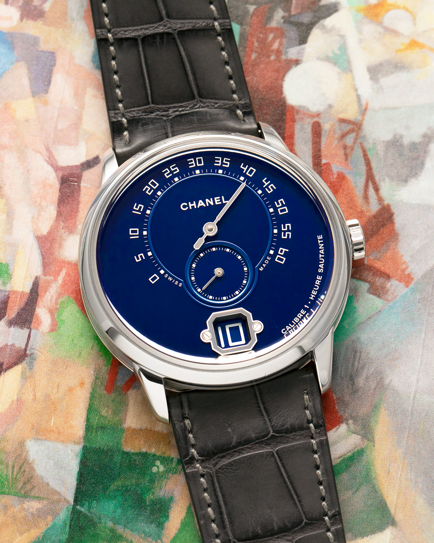 Brand: Chanel
Year: 2018
Model: Monsieur De Chanel Jump Hour, Limited to 20 Pieces
Reference: H5467
Material: Platinum 950 Case and Deployant Clasp, Blue Enamel Dial
Movement: Chanel Calibre 1 (Developed with Romain Gauthier), Manual-Winding 
Case Dimensions: 40mm x 10.4mm
Lug Width: 22mm
Straps: Chanel Grey Alligator Leather Strap with Signed Platinum 950 Deployant Clasp, with extra Chanel Black Alligator Leather Strap (Used)