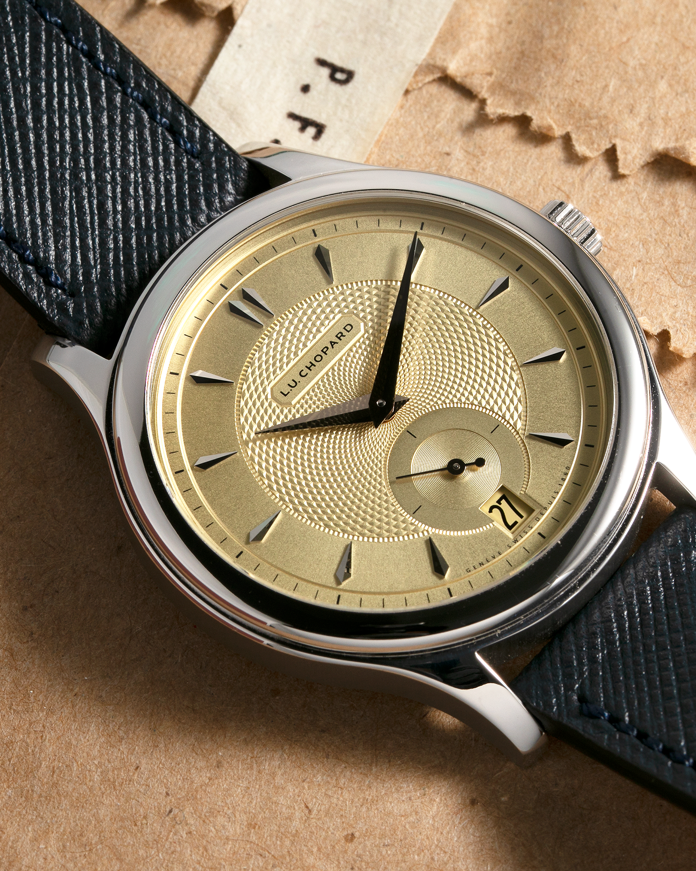 Brand: Chopard L.U.C. Year: 2022 Model / Reference: 16/1860/10018, The Hour Glass Limited Edition of 10 Pieces Serial Number: 425XXXX Material: 18-carat White Gold, Champagne Gold Dial Movement: Chopard Cal. L.U.C. 96.01-L, Self-Winding Case Diameter: 37mm Lug Width: 18mm Strap: Molequin Navy Blue Textured Calf Leather Strap with Signed 18-carat White Gold Tang buckle, and additional Chopard Distressed Sand Leather Strap