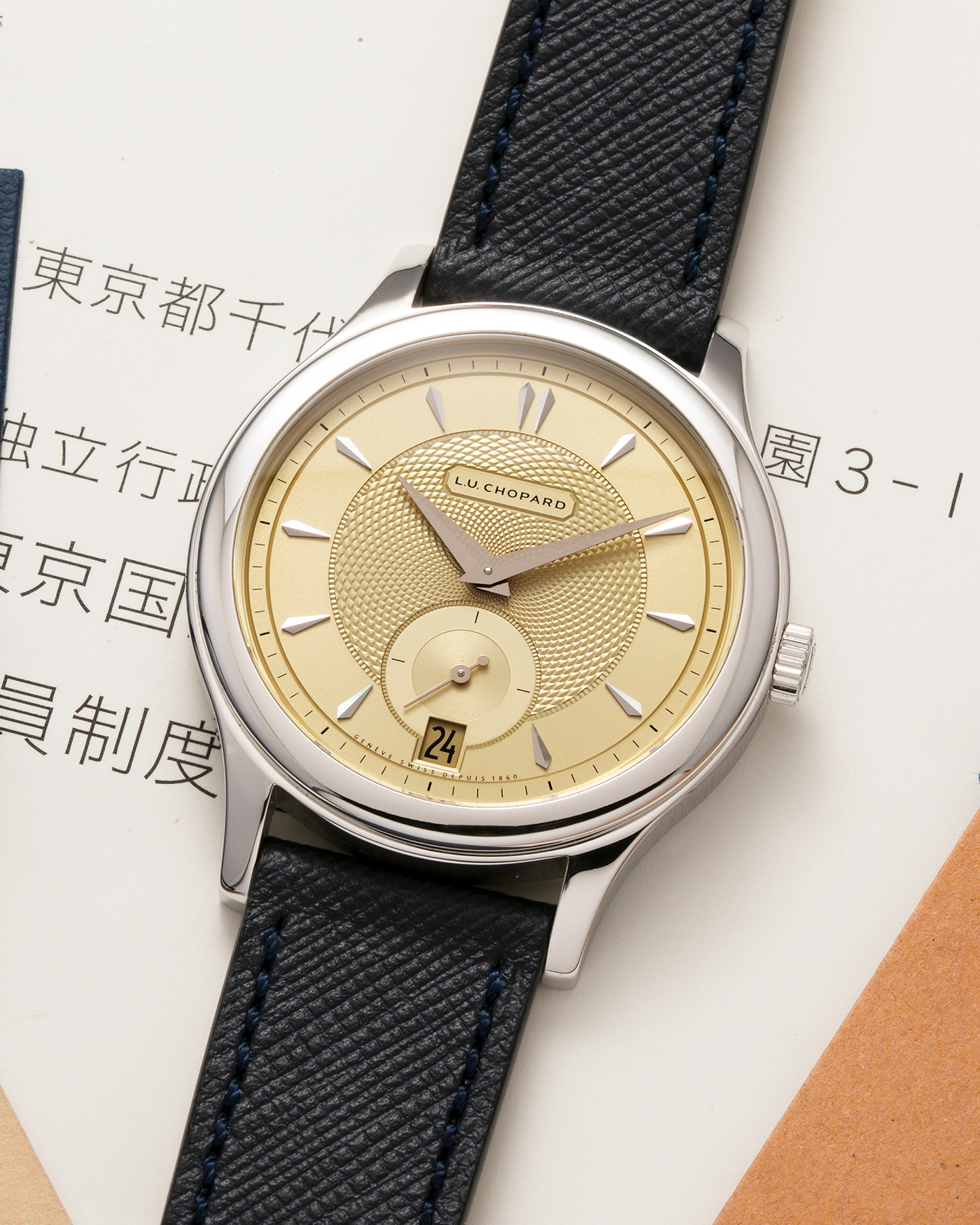Brand: Chopard L.U.C. Year: 2022 Model / Reference: 16/1860/10018, The Hour Glass Limited Edition of 10 Pieces Serial Number: 425XXXX Material: 18-carat White Gold, Champagne Gold Dial Movement: Chopard Cal. L.U.C. 96.01-L, Self-Winding Case Diameter: 37mm Lug Width: 18mm Strap: Molequin Navy Blue Textured Calf Leather Strap with Signed 18-carat White Gold Tang buckle, and additional Chopard Distressed Sand Leather Strap