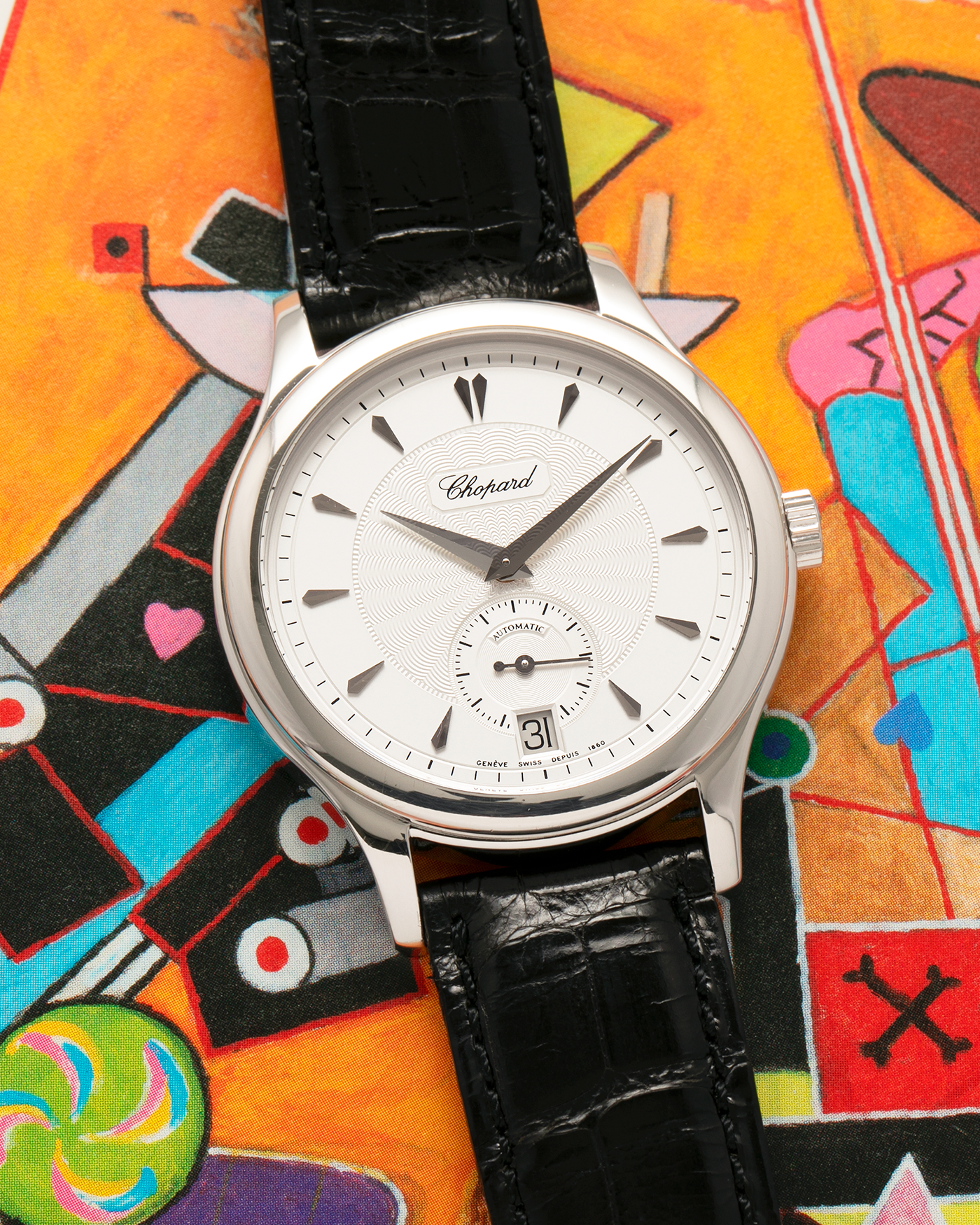 Brand: Chopard L.U.C.
Year: 1990’s
Model: 16/1860/2
Material: 18-carat White Gold
Movement: Chopard Cal. 1.96, Self-Winding Micro-Rotor
Case Dimensions: 37mm x 8.5mm (Lug-to-Lug 45mm)
Lug Width: 18mm
Strap: Chopard Black Alligator Leather Strap with Signed 18-carat White Gold Tang Buckle