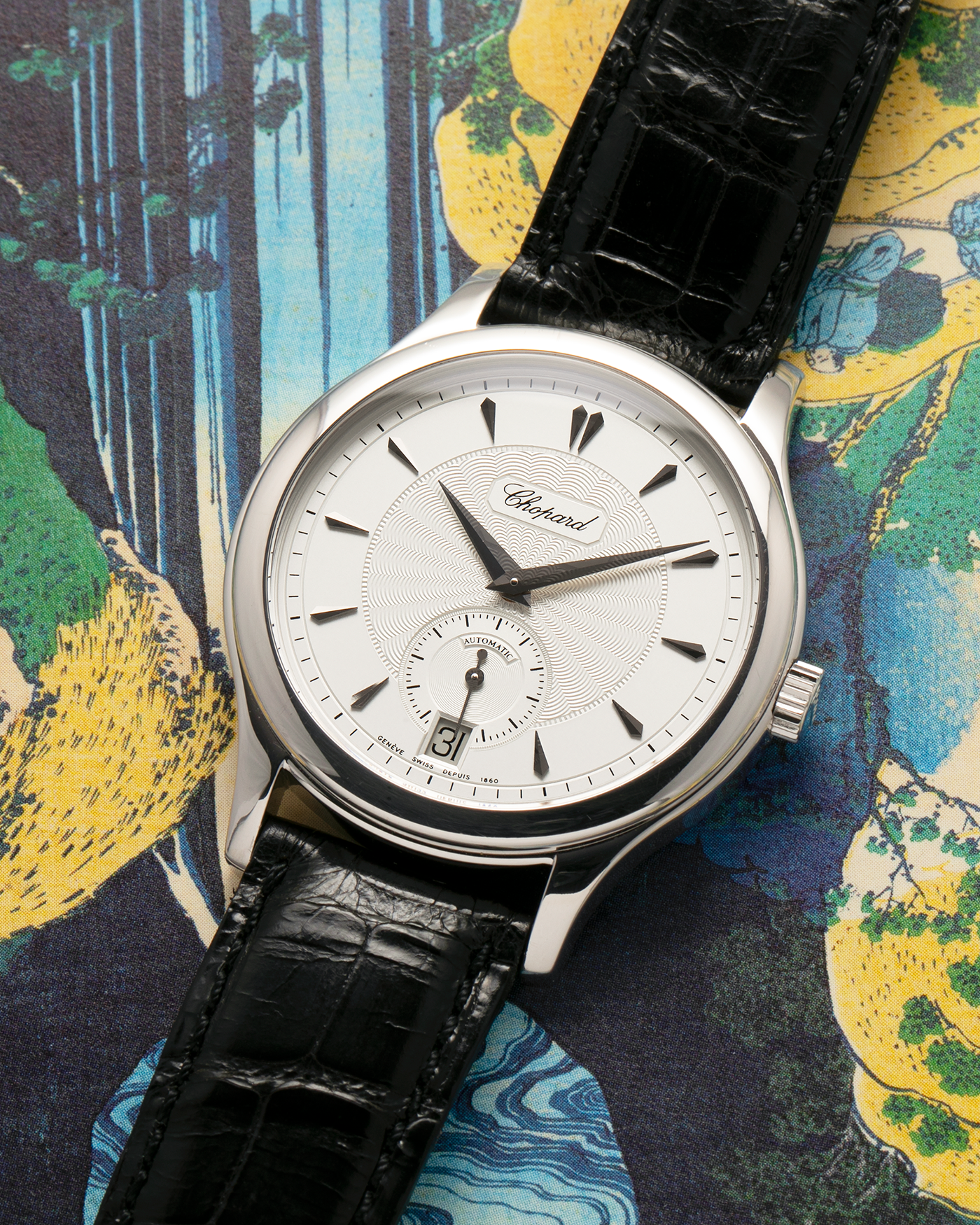 Brand: Chopard L.U.C.
Year: 1990’s
Model: 16/1860/2
Material: 18-carat White Gold
Movement: Chopard Cal. 1.96, Self-Winding Micro-Rotor
Case Dimensions: 37mm x 8.5mm (Lug-to-Lug 45mm)
Lug Width: 18mm
Strap: Chopard Black Alligator Leather Strap with Signed 18-carat White Gold Tang Buckle