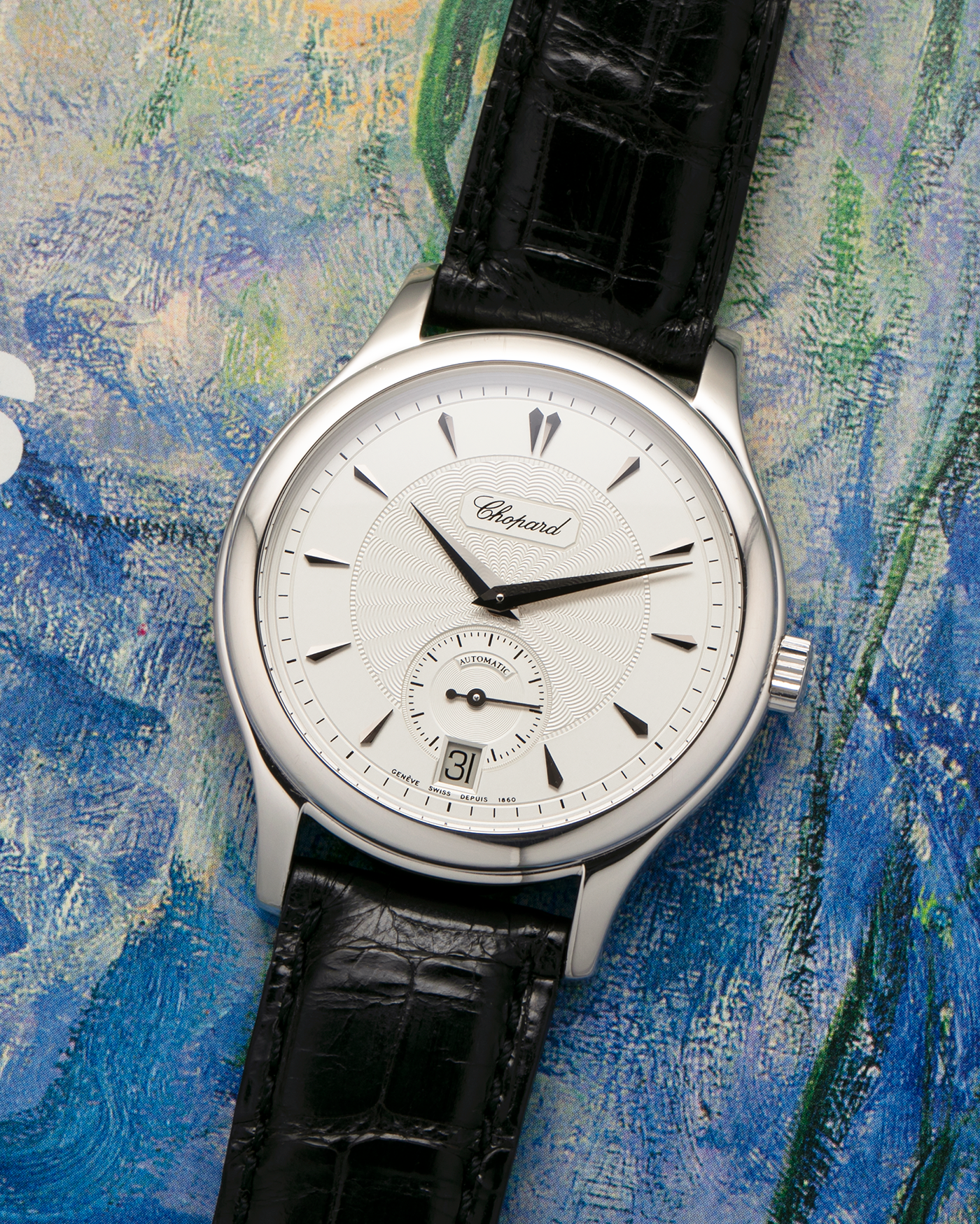 Brand: Chopard L.U.C.
Year: 1990’s
Model: 16/1860/2
Material: 18-carat White Gold
Movement: Chopard Cal. 1.96, Self-Winding Micro-Rotor
Case Dimensions: 37mm x 8.5mm (Lug-to-Lug 45mm)
Lug Width: 18mm
Strap: Chopard Black Alligator Leather Strap with Signed 18-carat White Gold Tang Buckle