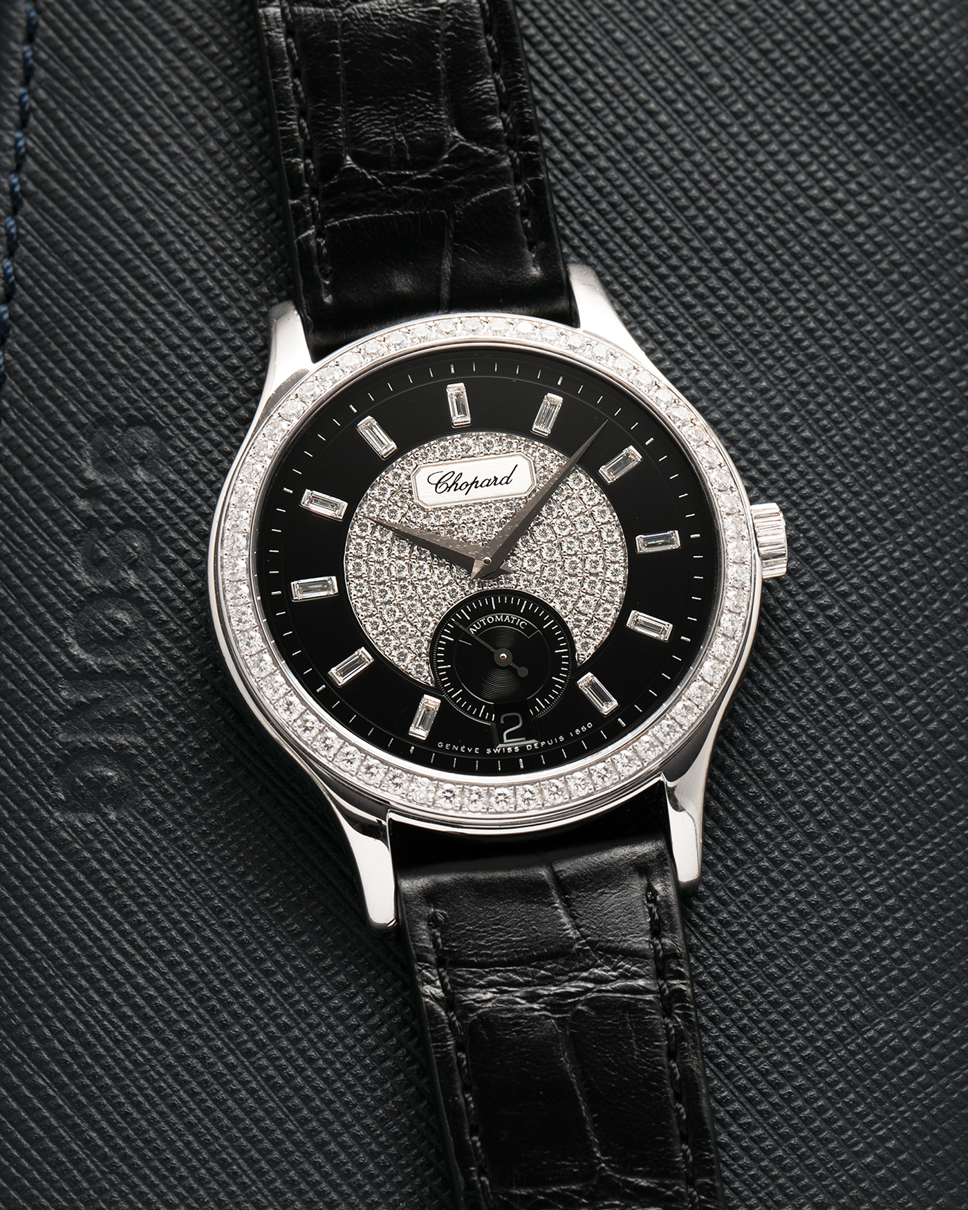 Brand: Chopard L.U.C.
Year: 2000’s
Model: 17/1873/2 Based Off 16/1860/2
Material: 18-carat White Gold Case, Factory-Set Diamond Bezel and Dial
Movement: Chopard Cal. 1.96, Self-Winding Micro-Rotor
Case Dimensions: 37mm Diameter 8.5mm Thickness
Lug Width: 18mm
Strap: Chopard Black Alligator Strap with 18k White Gold Chopard Tang Buckle
