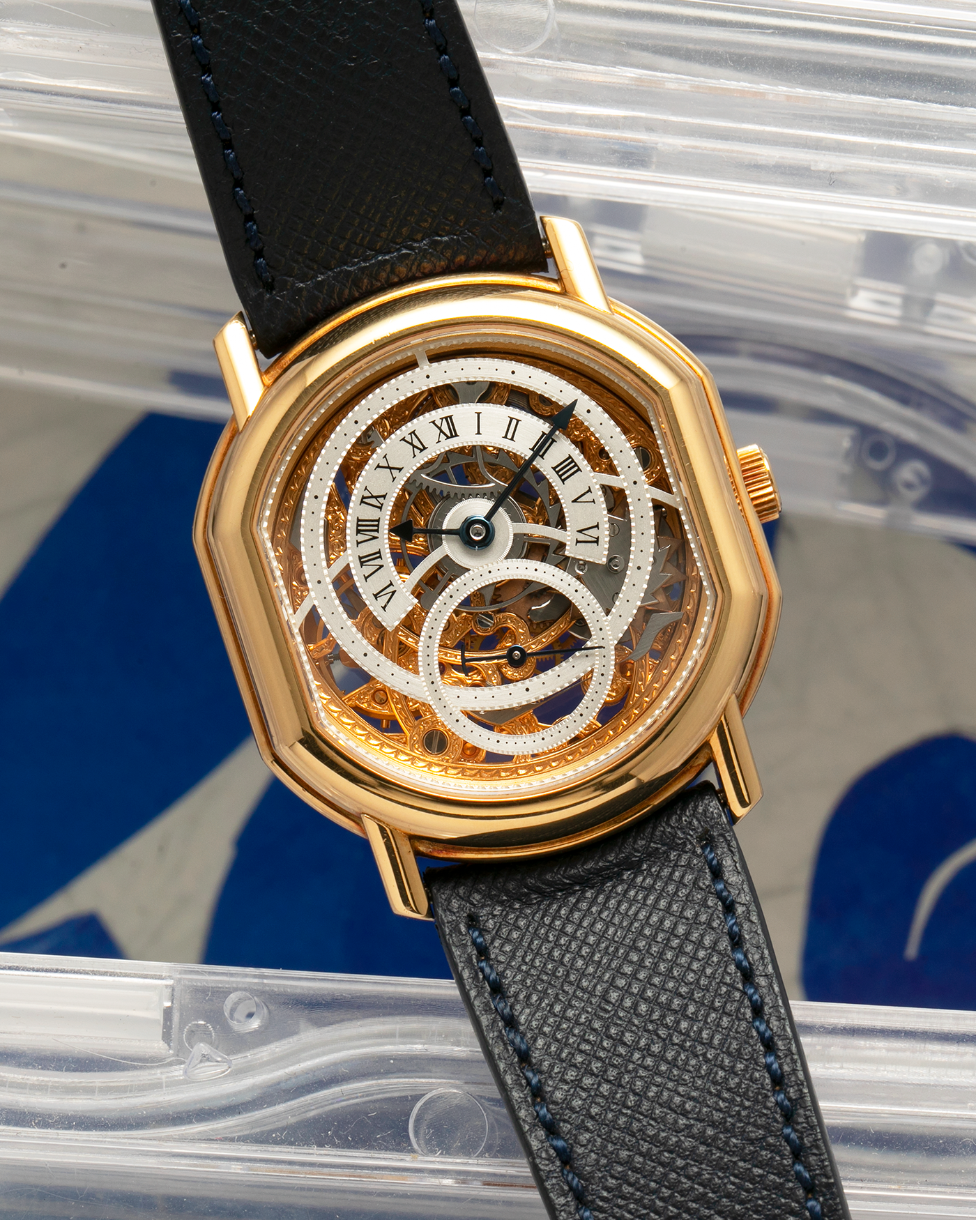 Brand: Daniel Roth
Year: 1990’s
Model: 2127 Retrograde Skeleton
Material: 18-carat Yellow Gold
Movement: Lemania Cal. 27LN with Retrograde Function, Manual-Winding
Case Diameter: 35mm x 38mm (41mm Lug-to-Lug)
Lug Width: 20mm
Strap: Molequin Navy Blue Grained Calf Strap with Signed 18-carat Yellow Gold Tang Buckle