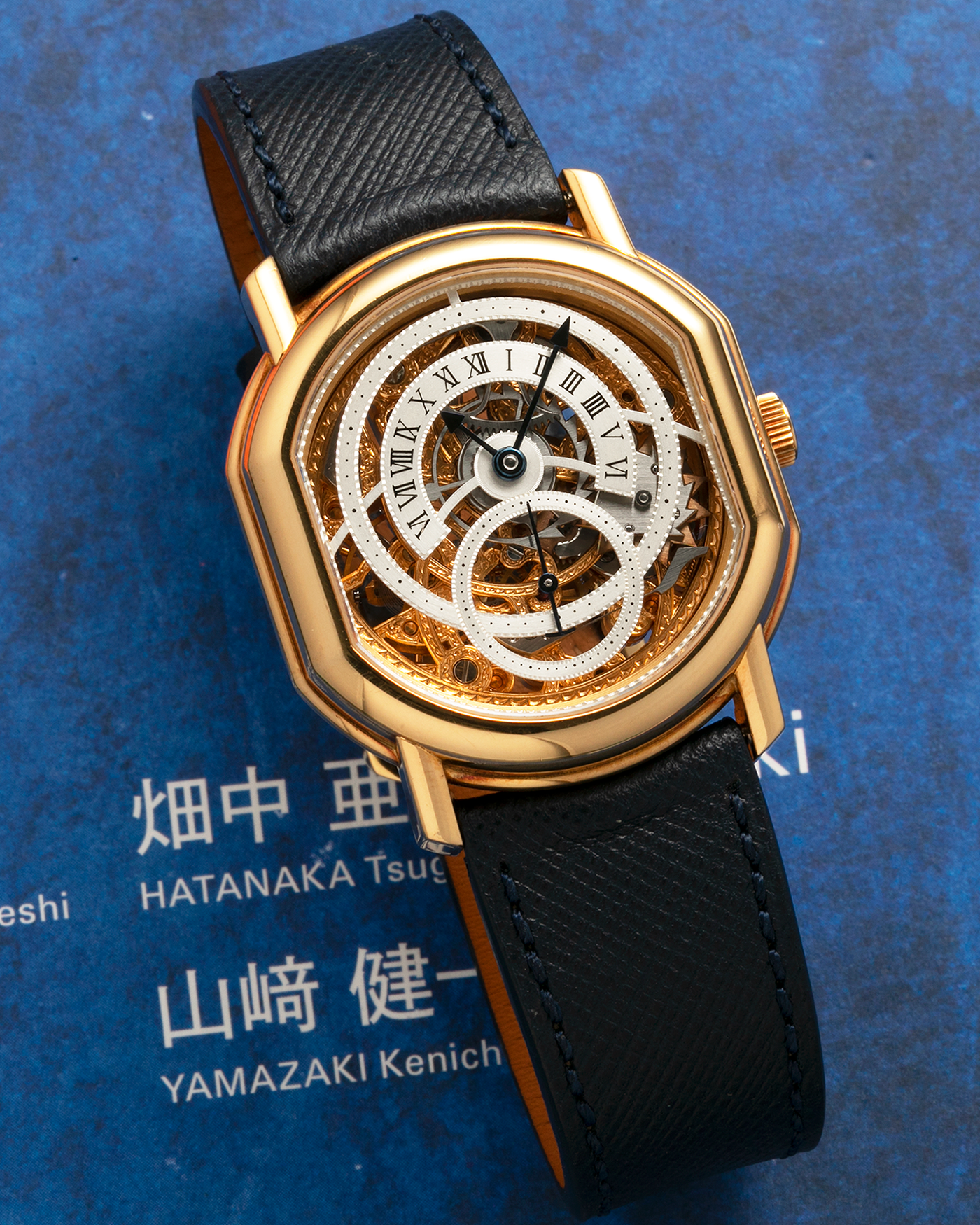 Brand: Daniel Roth
Year: 1990’s
Model: 2127 Retrograde Skeleton
Material: 18-carat Yellow Gold
Movement: Lemania Cal. 27LN with Retrograde Function, Manual-Winding
Case Diameter: 35mm x 38mm (41mm Lug-to-Lug)
Lug Width: 20mm
Strap: Molequin Navy Blue Grained Calf Strap with Signed 18-carat Yellow Gold Tang Buckle