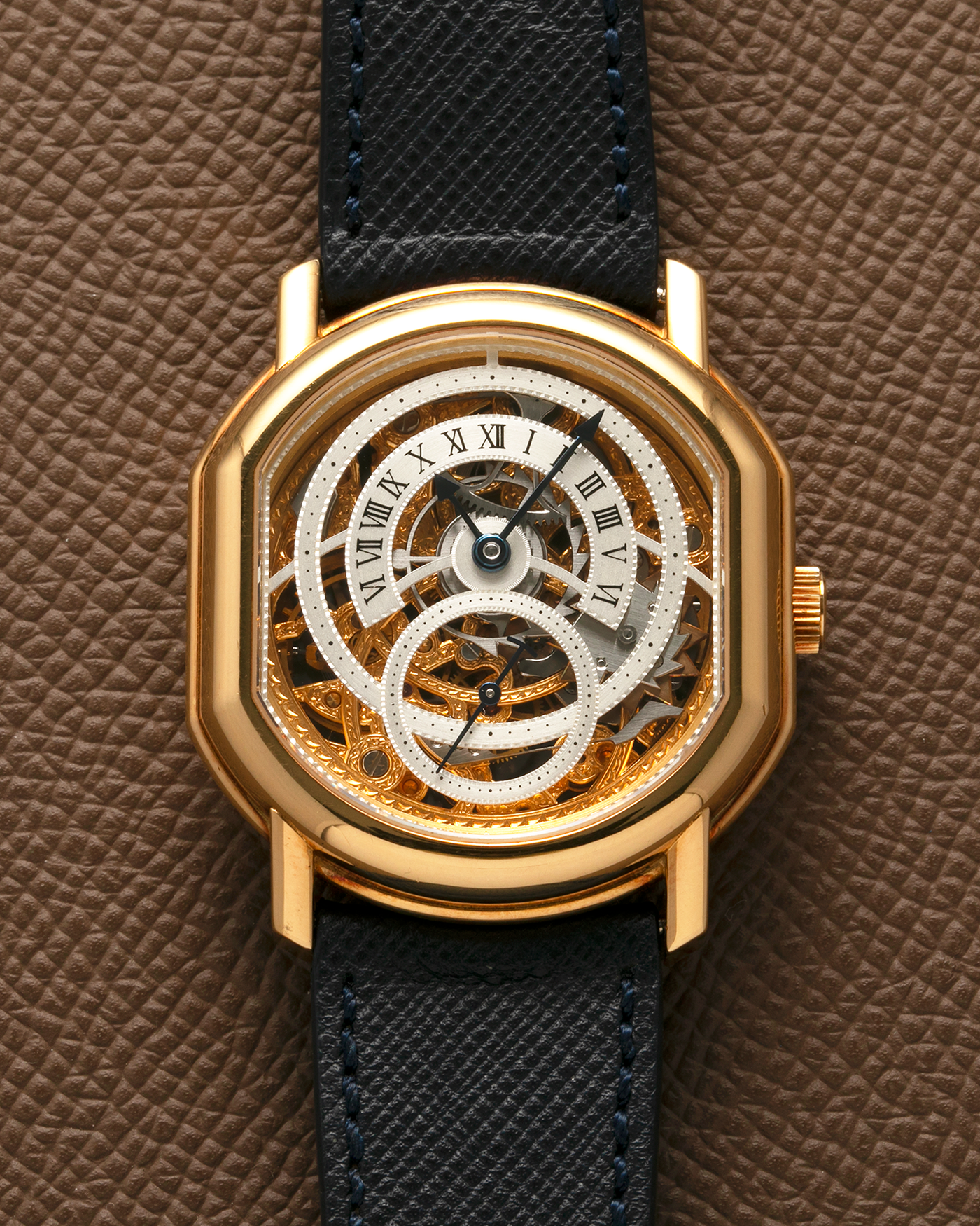 Brand: Daniel Roth
Year: 1990’s
Model: 2127 Retrograde Skeleton
Material: 18-carat Yellow Gold
Movement: Lemania Cal. 27LN with Retrograde Function, Manual-Winding
Case Diameter: 35mm x 38mm (41mm Lug-to-Lug)
Lug Width: 20mm
Strap: Molequin Navy Blue Grained Calf Strap with Signed 18-carat Yellow Gold Tang Buckle