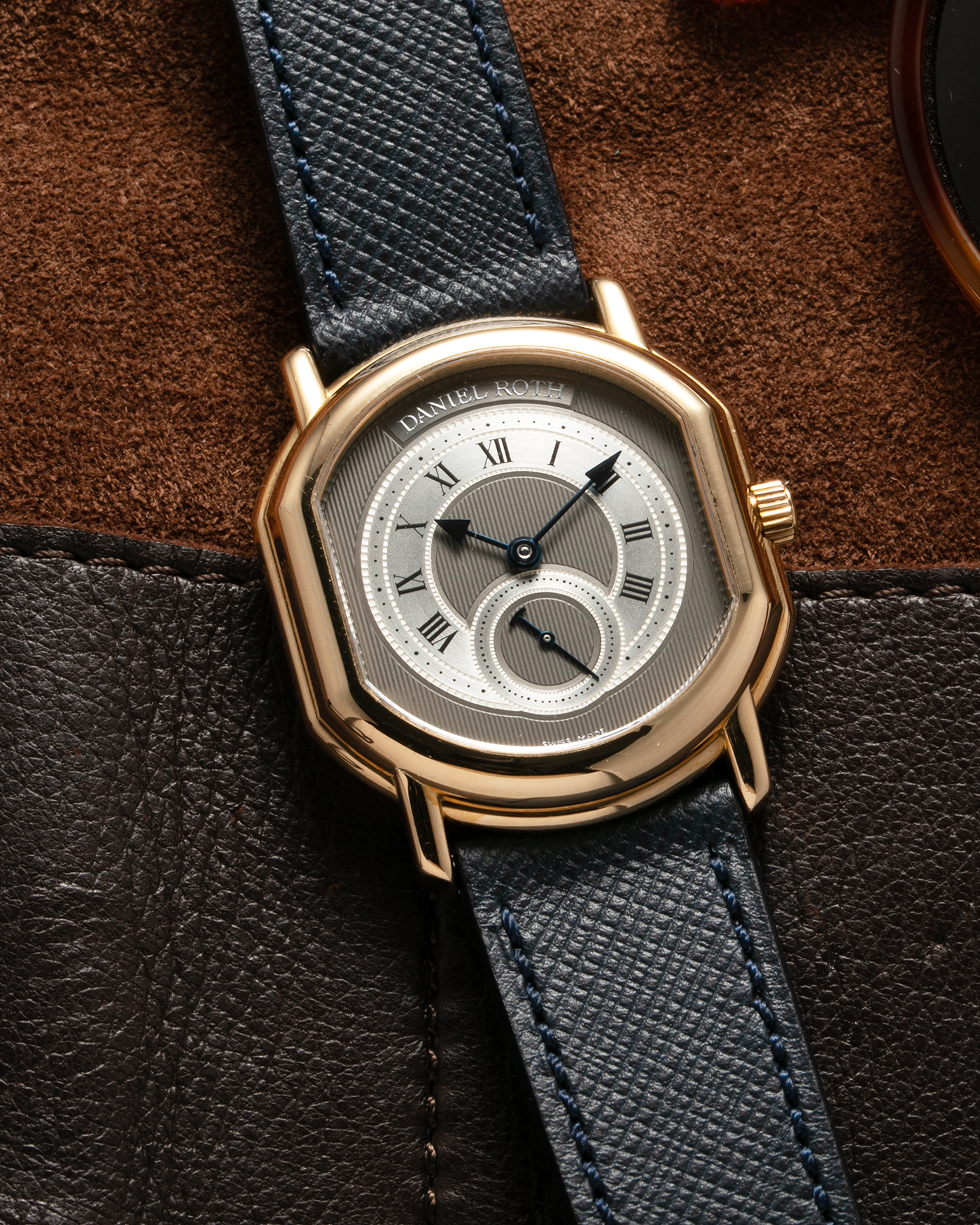 Brand: Daniel Roth Year: 1990’s Model: Seconds at Six, Mid-Size Material: 18-carat Yellow Gold  Movement: Lemania Cal. 1918, Self-Winding Case Dimensions: 35mm x 32mm Lug Width: 18mm Strap: Molequin Navy Textured Calf Leather Strap with Generic Stainless Steel Tang Buckle