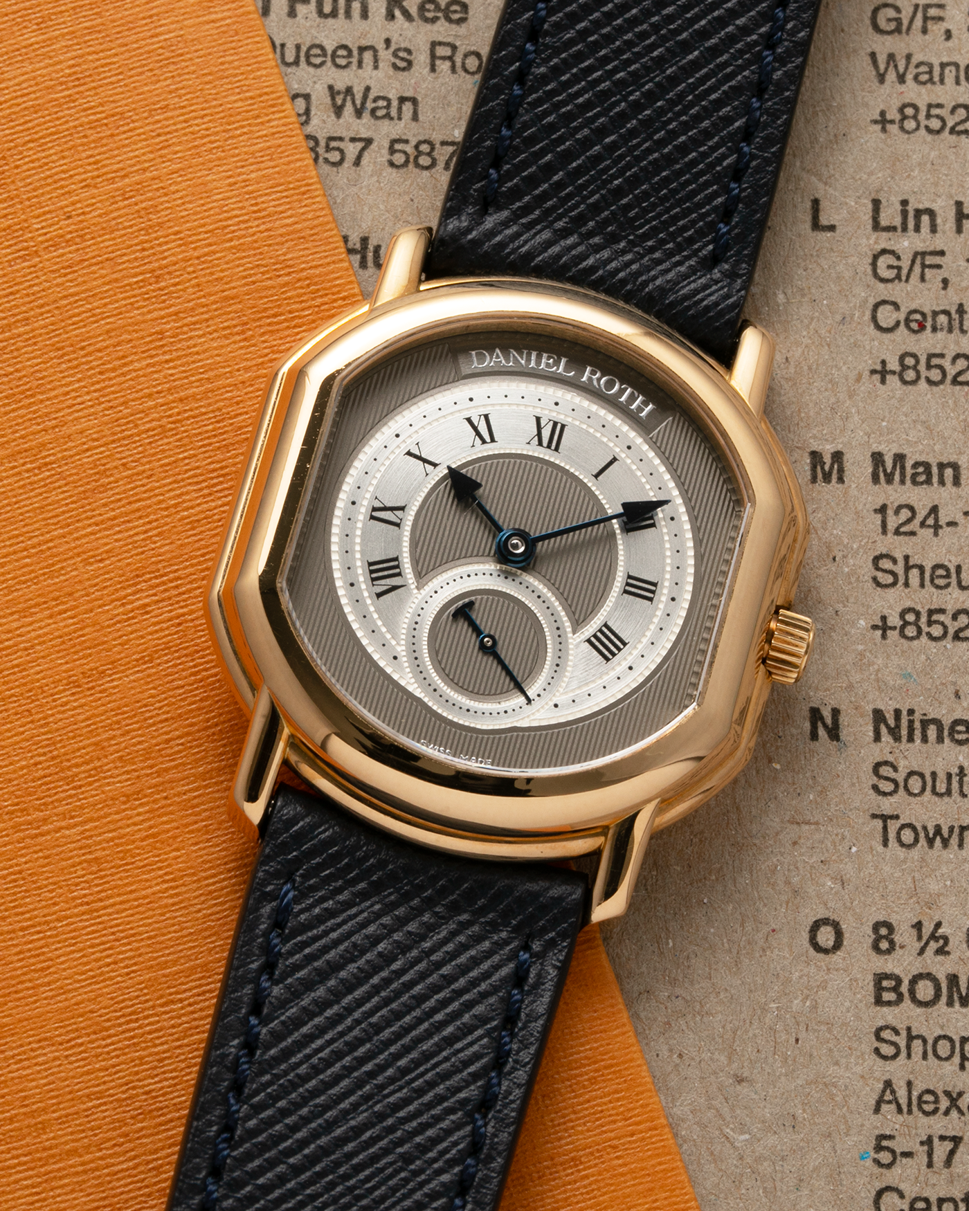 Brand: Daniel Roth Year: 1990’s Model: Seconds at Six, Mid-Size Material: 18-carat Yellow Gold  Movement: Lemania Cal. 1918, Self-Winding Case Dimensions: 35mm x 32mm Lug Width: 18mm Strap: Molequin Navy Textured Calf Leather Strap with Generic Stainless Steel Tang Buckle