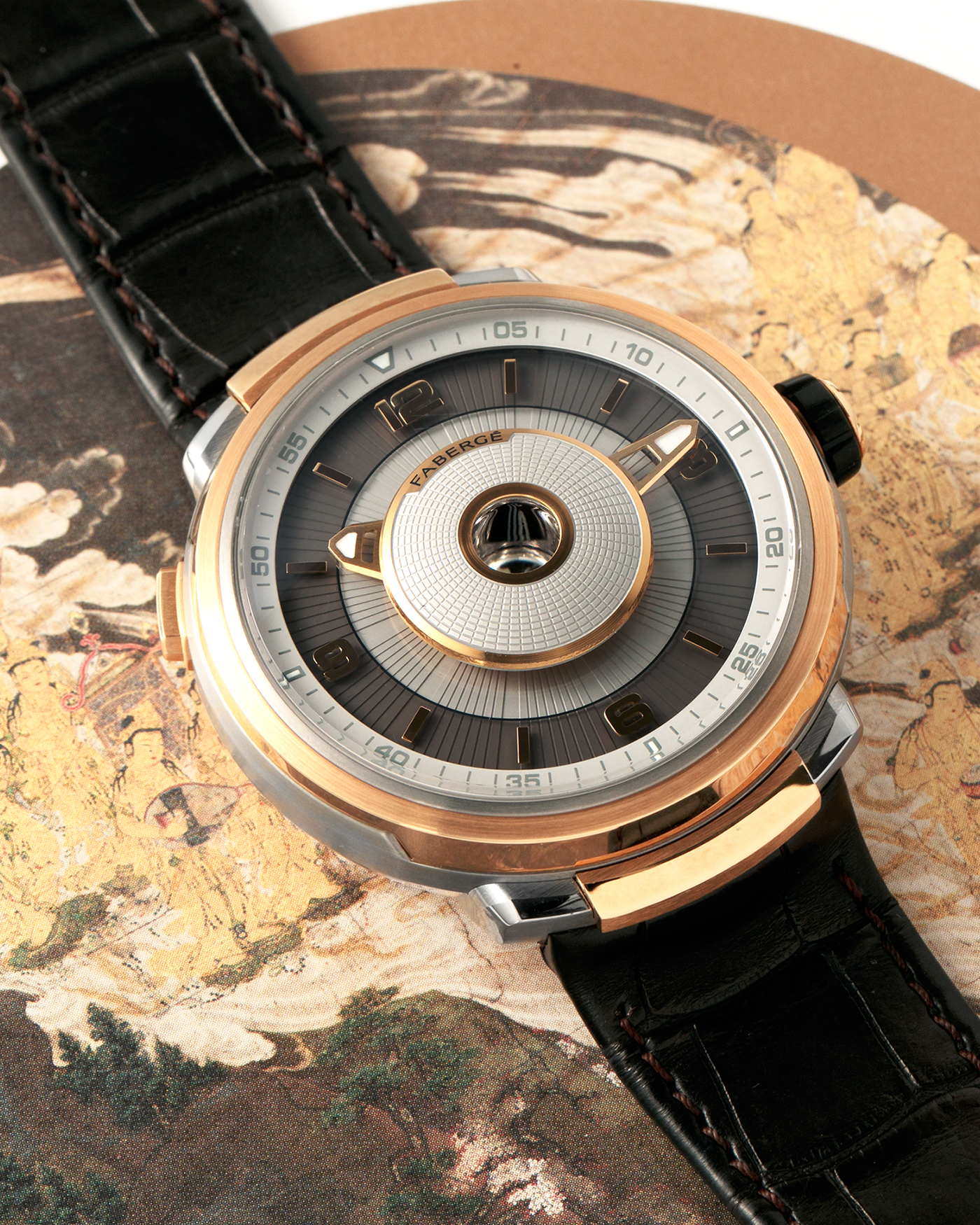 Brand: Fabergé
Year: 2016 (Approximation)
Model: Visionnaire DTZ Dual Time Zone
Material: 18k Rose Gold and Titanium
Movement: Self-Winding Agenhor AGH 6924 (Peripheral Rotor)
Case Dimensions: 43m Diameter 14.2mm Thickness
Strap: Fabergé Black Alligator Strap With Signed 18k Rose Gold Deployant Clasp
