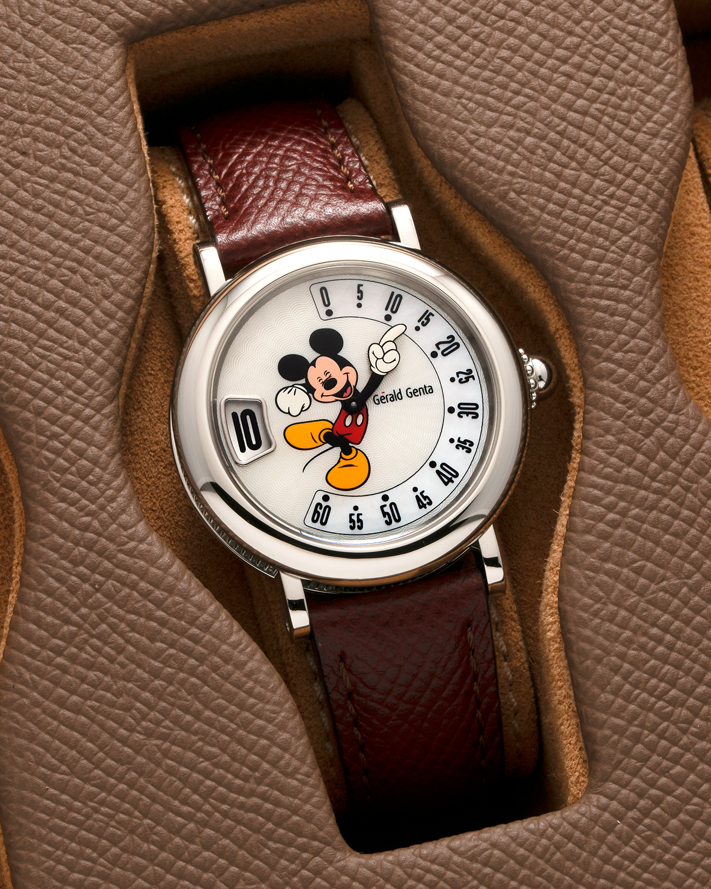 Brand: Gérald Genta Year: 2008 Model: Retro Fantasy ‘Mickey Mouse’ Reference Number: Ref.M.10.065.CR.BA Serial Number: 105XXX Material: Stainless Steel Case, Mother-of-Pearl dial Movement: Cal. ETA 2892A2, Self-Winding Case Diameter: 36mm Lug Width: 18mm Strap: Generic Oxblood Lizard Leather Strap with Signed Stainless Steel Tang Buckle, with additional Gérald Genta Burgundy Red Alligator Leather Strap