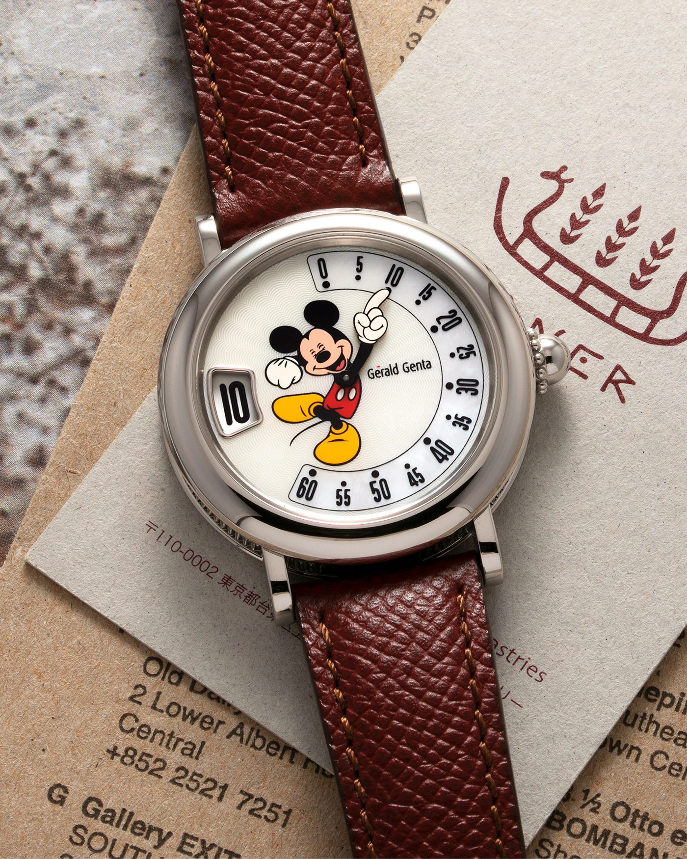 Brand: Gérald Genta Year: 2008 Model: Retro Fantasy ‘Mickey Mouse’ Reference Number: Ref.M.10.065.CR.BA Serial Number: 105XXX Material: Stainless Steel Case, Mother-of-Pearl dial Movement: Cal. ETA 2892A2, Self-Winding Case Diameter: 36mm Lug Width: 18mm Strap: Generic Oxblood Lizard Leather Strap with Signed Stainless Steel Tang Buckle, with additional Gérald Genta Burgundy Red Alligator Leather Strap