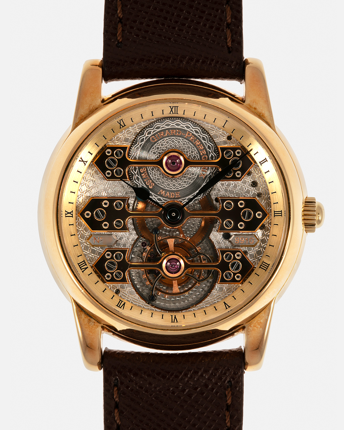 Brand: Girard Perregaux  Year: Mid-1990s Model: Three Bridges Tourbillon, “Tourbillon Sous Trois Ponts d'Or” Reference: 99000 Material: 18-carat Yellow Gold  Movement: Girard Perregaux Cal. 9910 Tourbillon, Manual-Winding  Case Dimensions: 39mm x 10.5mm (Lug-to-Lug 44.5mm)  Lug Width: 20mm  Strap: Phillips Dark Brown Textured Calf Leather Strap with Signed 18-carat Yellow Gold Tang Buckle 