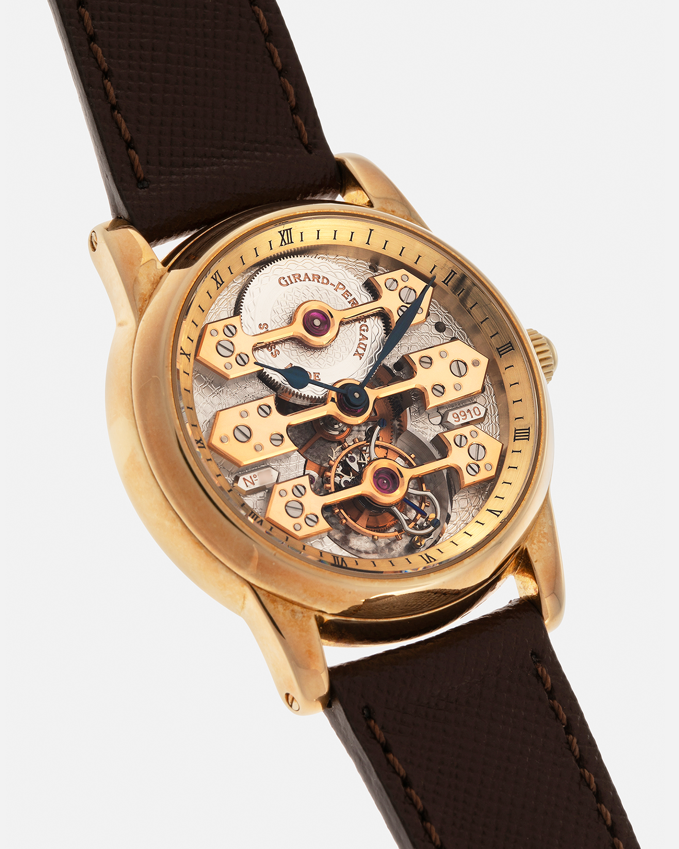 Brand: Girard Perregaux  Year: Mid-1990s Model: Three Bridges Tourbillon, “Tourbillon Sous Trois Ponts d'Or” Reference: 99000 Material: 18-carat Yellow Gold  Movement: Girard Perregaux Cal. 9910 Tourbillon, Manual-Winding  Case Dimensions: 39mm x 10.5mm (Lug-to-Lug 44.5mm)  Lug Width: 20mm  Strap: Phillips Dark Brown Textured Calf Leather Strap with Signed 18-carat Yellow Gold Tang Buckle 