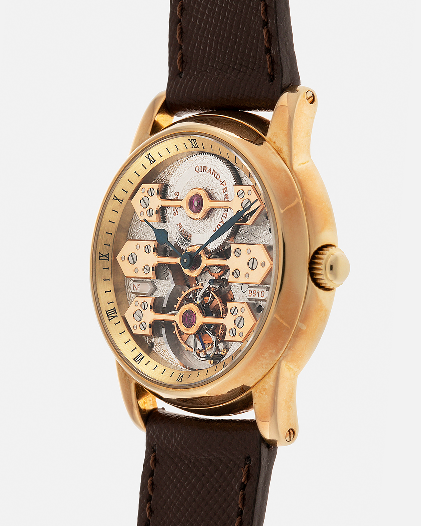 Brand: Girard Perregaux  Year: Mid-1990s Model: Three Bridges Tourbillon, “Tourbillon Sous Trois Ponts d'Or” Reference: 99000 Material: 18-carat Yellow Gold  Movement: Girard Perregaux Cal. 9910 Tourbillon, Manual-Winding  Case Dimensions: 39mm x 10.5mm (Lug-to-Lug 44.5mm)  Lug Width: 20mm  Strap: Phillips Dark Brown Textured Calf Leather Strap with Signed 18-carat Yellow Gold Tang Buckle 