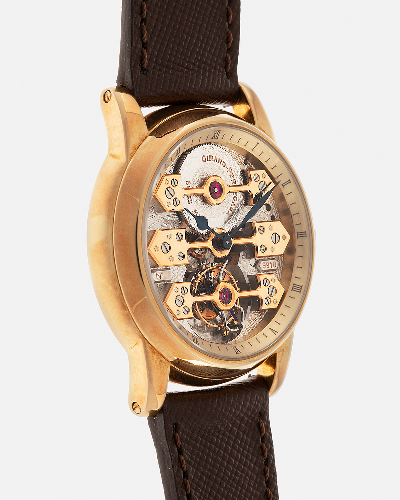 Brand: Girard Perregaux  Year: Mid-1990s Model: Three Bridges Tourbillon, “Tourbillon Sous Trois Ponts d'Or” Reference: 99000 Material: 18-carat Yellow Gold  Movement: Girard Perregaux Cal. 9910 Tourbillon, Manual-Winding  Case Dimensions: 39mm x 10.5mm (Lug-to-Lug 44.5mm)  Lug Width: 20mm  Strap: Phillips Dark Brown Textured Calf Leather Strap with Signed 18-carat Yellow Gold Tang Buckle 