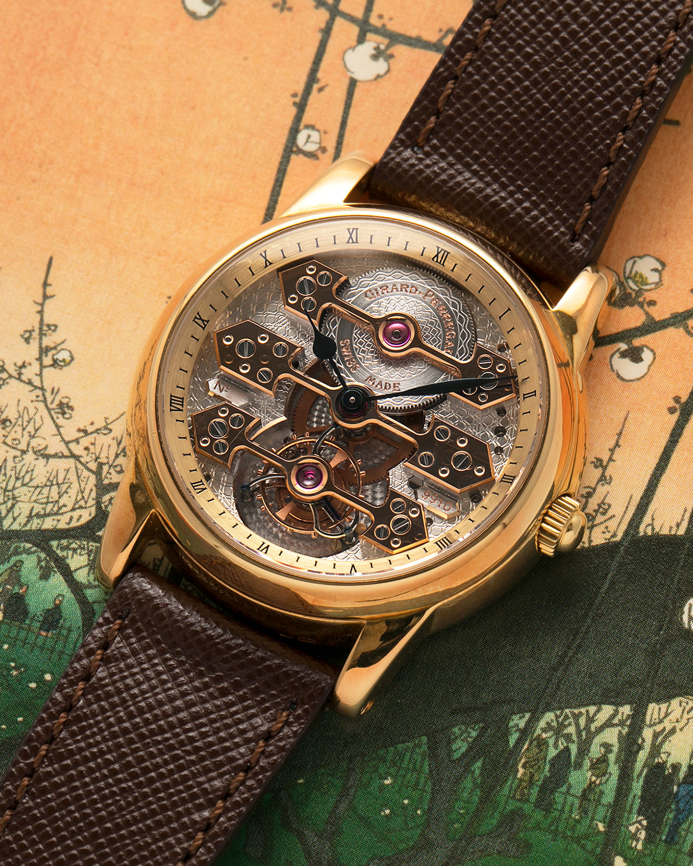 Brand: Girard Perregaux  Year: Mid-1990s Model: Three Bridges Tourbillon, “Tourbillon Sous Trois Ponts d'Or” Reference: 99000 Material: 18-carat Yellow Gold  Movement: Girard Perregaux Cal. 9910 Tourbillon, Manual-Winding  Case Dimensions: 39mm x 10.5mm (Lug-to-Lug 44.5mm)  Lug Width: 20mm  Strap: Phillips Dark Brown Textured Calf Leather Strap with Signed 18-carat Yellow Gold Tang Buckle 