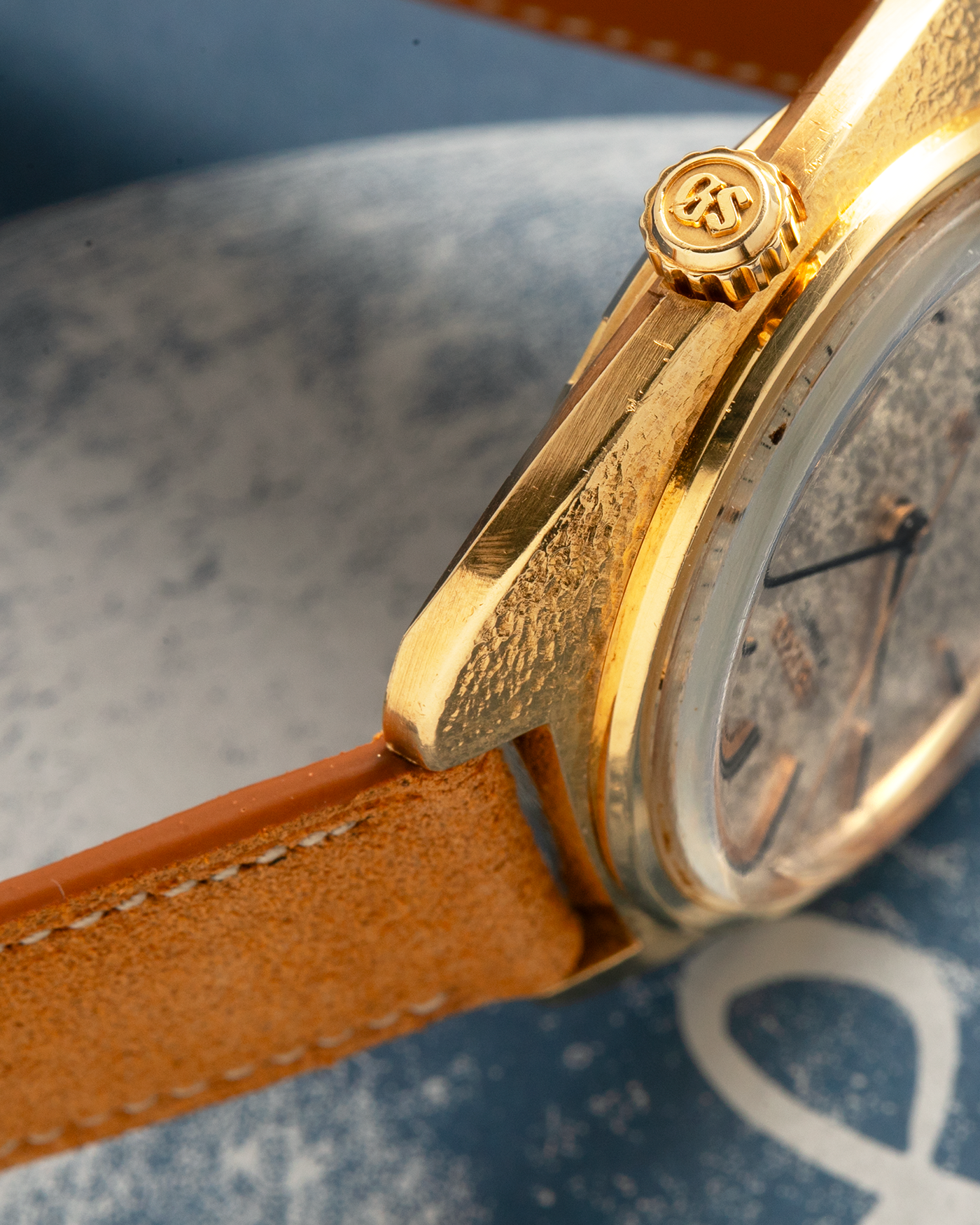 Brand: Grand Seiko
Year: Late 1960’s/1970’s
Model: 61GS
Reference Number: 6145-8030 ‘Kirazuri’
Material: 18-carat Yellow Gold
Movement: Self-Winding Hi Beat Cal. 6145
Case Dimensions: 37mm Diameter 11mm Thickness
Lug Width: 18mm
Strap: Nostime Tan Suede Strap with Generic Stainless Steel Buckle