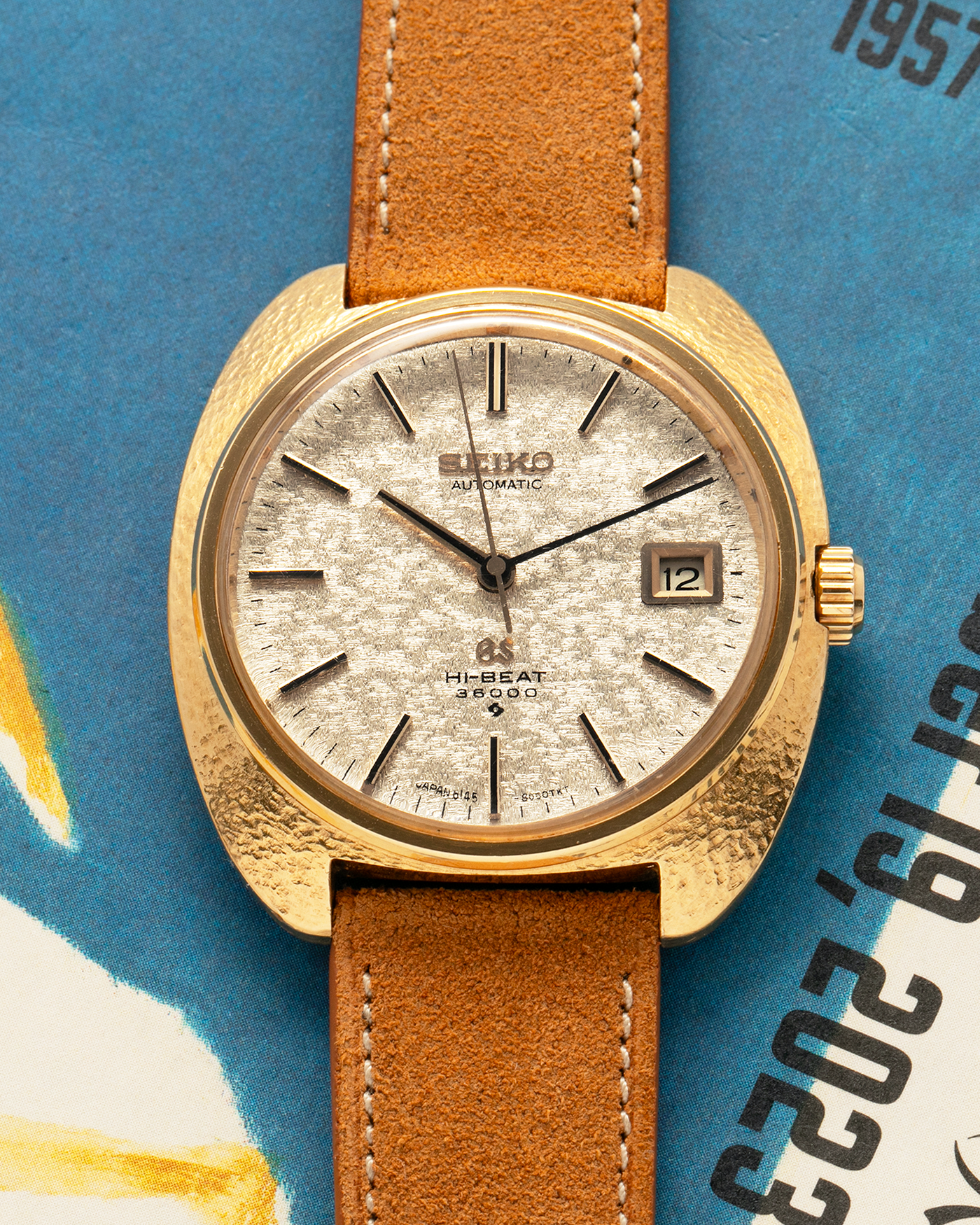 Brand: Grand Seiko
Year: Late 1960’s/1970’s
Model: 61GS
Reference Number: 6145-8030 ‘Kirazuri’
Material: 18-carat Yellow Gold
Movement: Self-Winding Hi Beat Cal. 6145
Case Dimensions: 37mm Diameter 11mm Thickness
Lug Width: 18mm
Strap: Nostime Tan Suede Strap with Generic Stainless Steel Buckle